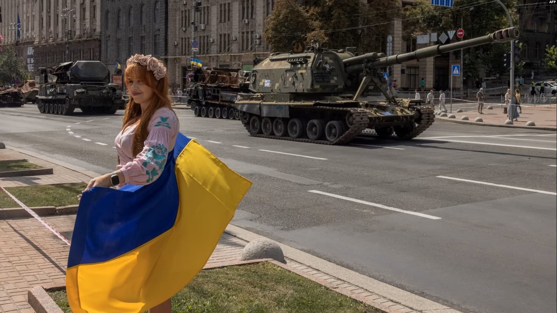 People look at a large number of burned out and captured Russian tanks and infantry carriers in Kyiv
