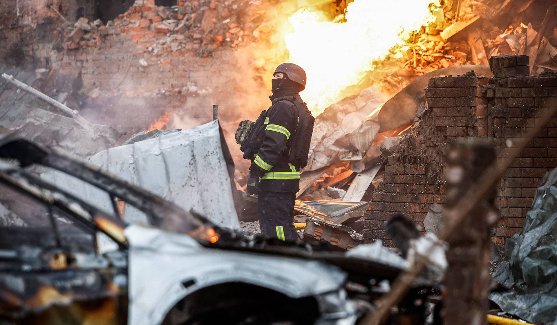 A firefighter works at the site of a residential building damaged during Russian drone and missile strikes in Kyiv