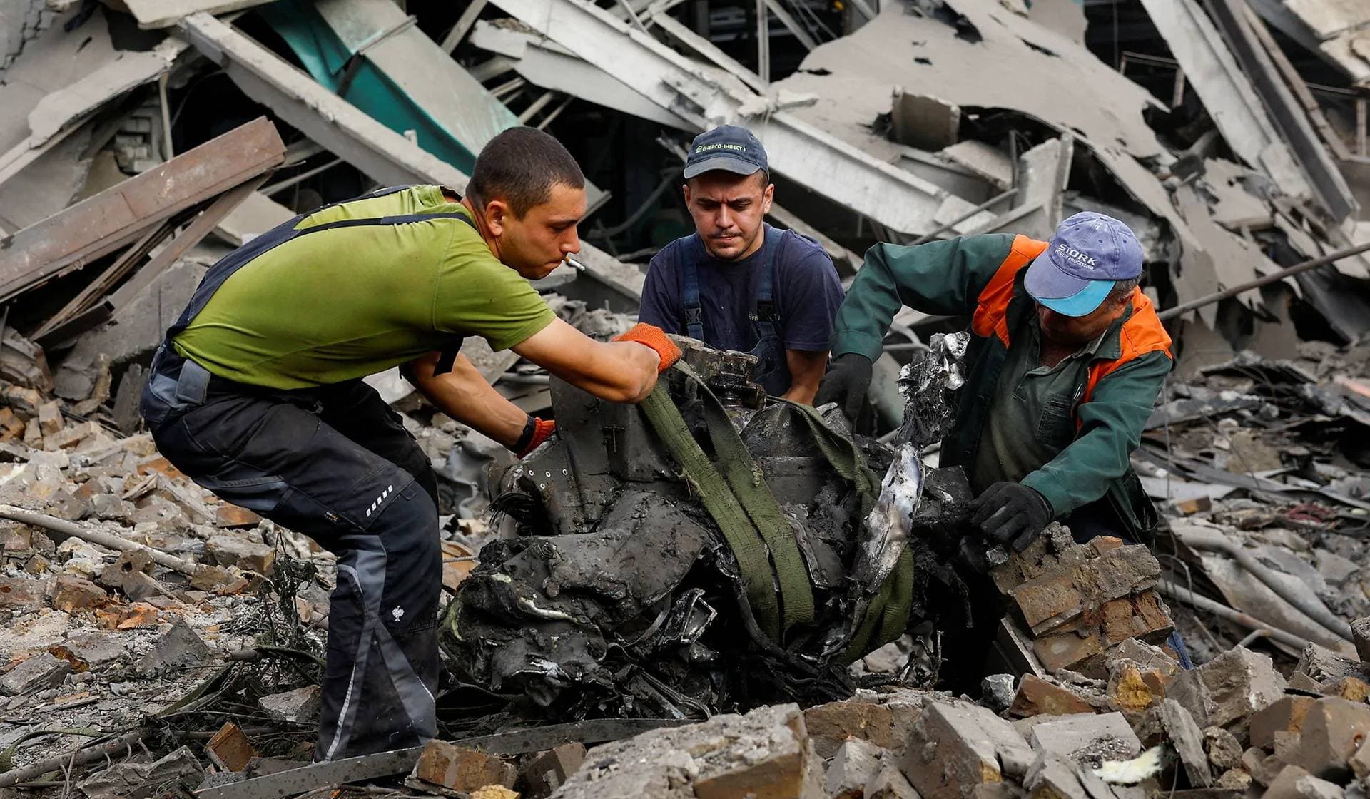 Workers extract the remnants of a Russian missile at a site in an industrial area damaged during a Russian missile strike in Kyiv
