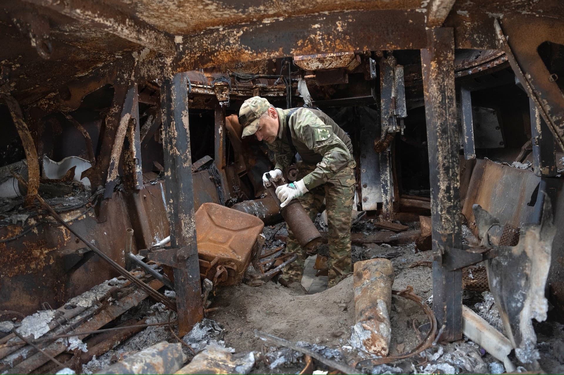 A sapper inspects a damaged Russian self-propelled artillery vehicle installed as a symbol of war in central Kyiv