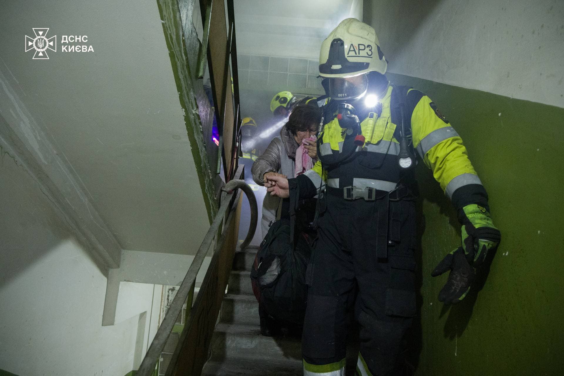 Rescuers evacuate a resident from an apartment building damaged by a Russian drone strike in Kyiv