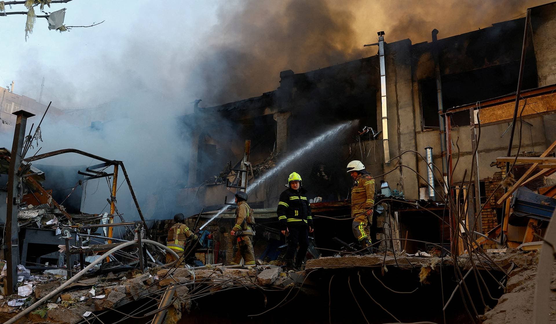 Firefighters work at the site of a car repair workshop damaged during Russian missile and drone strikes in Kyiv
