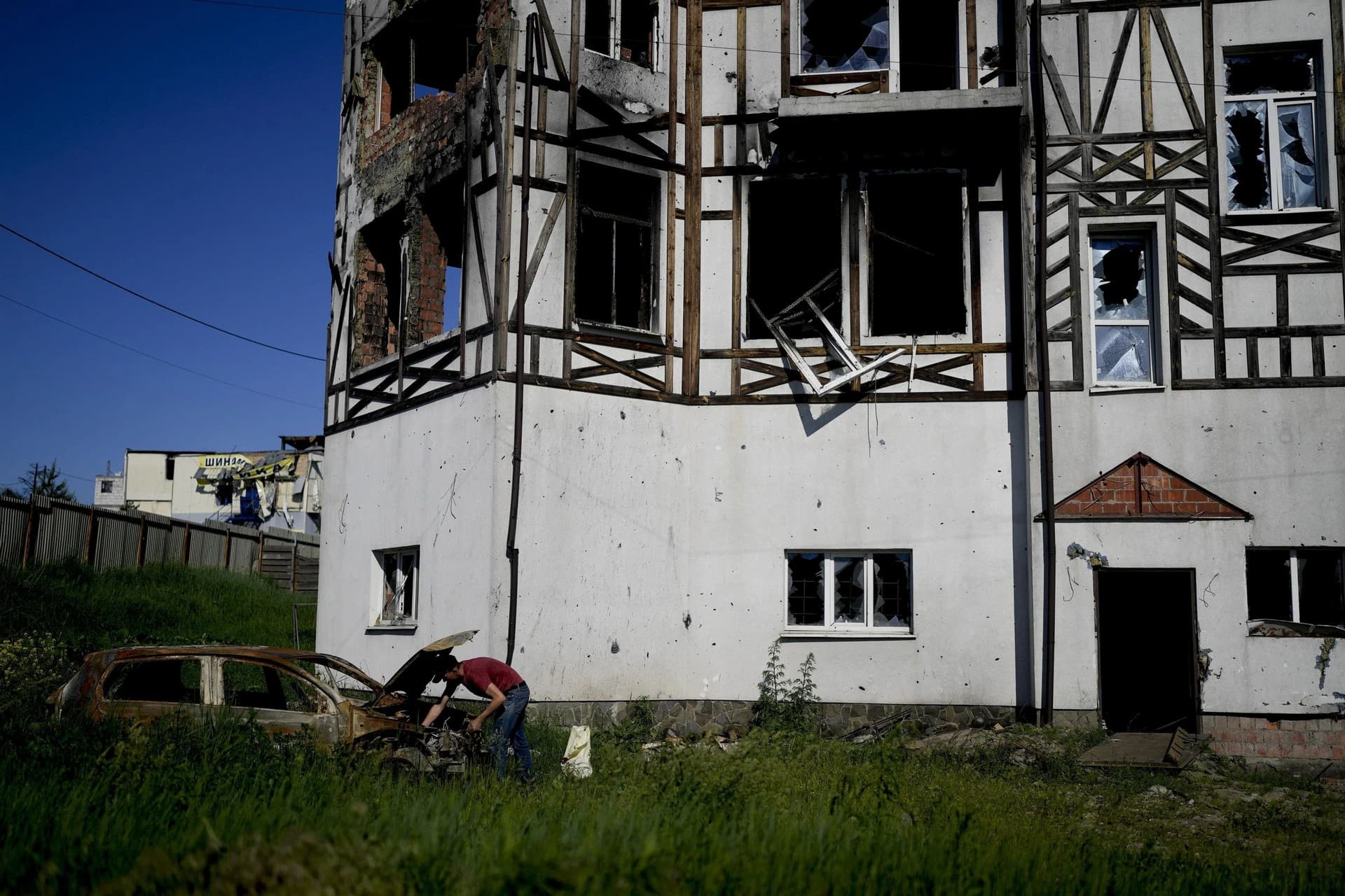 A man checks his car destroyed by attacks in Mostyshche