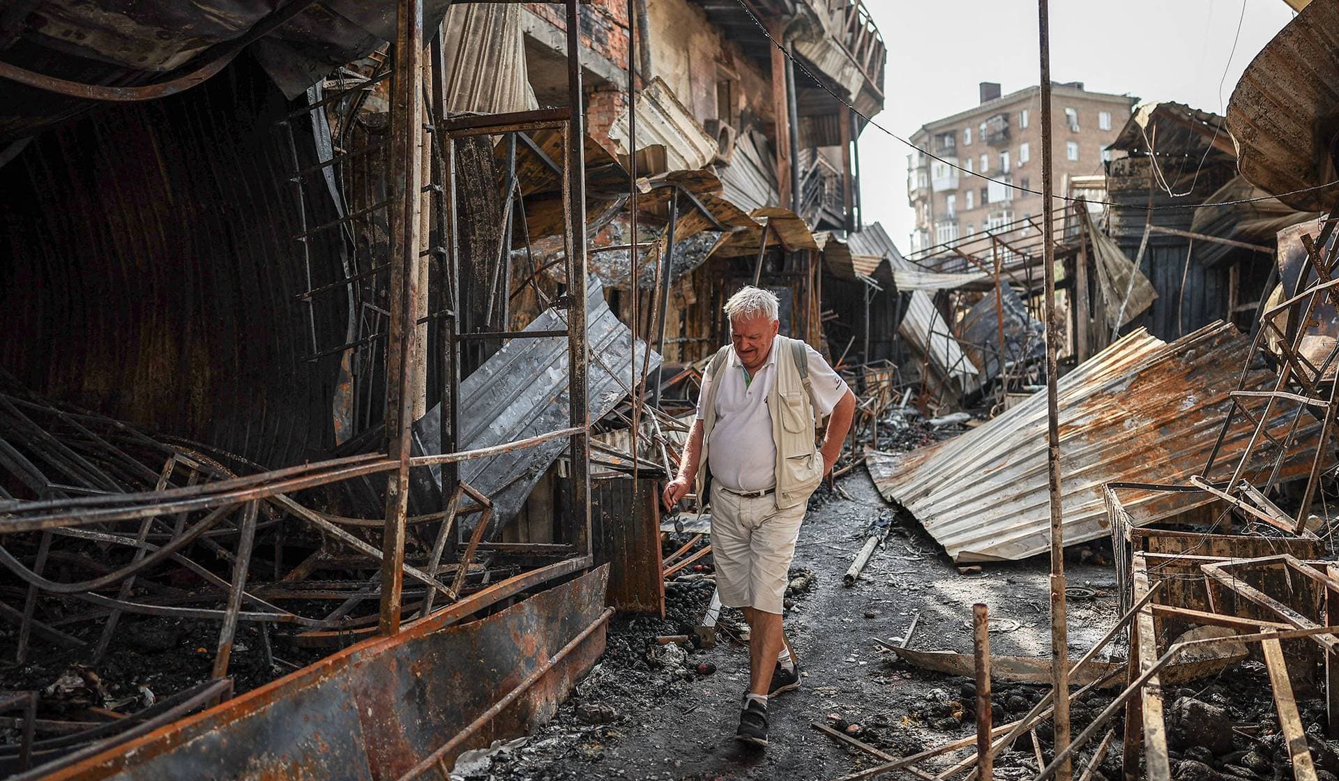 A man walks through debris of a demolished market, which was hit during yesterday's Russian missile and drone attack in Kyiv