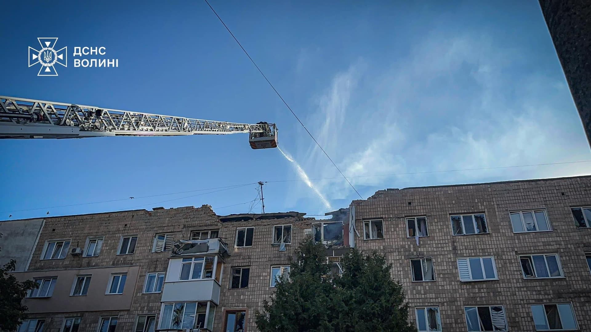 Firefighters work at the site where an apartment building was hit by a Russian drone strike in Lutsk