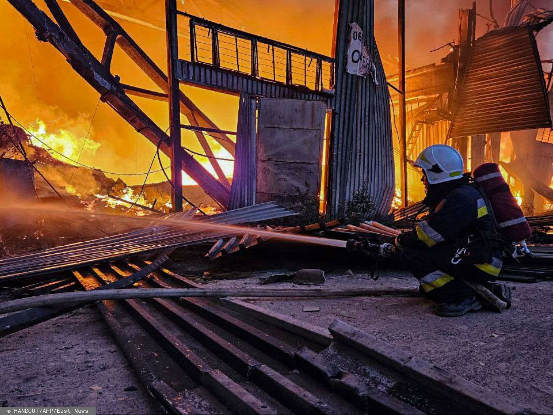 emergency services personnel work to extinguish a fire following a Russian attack in Lviv