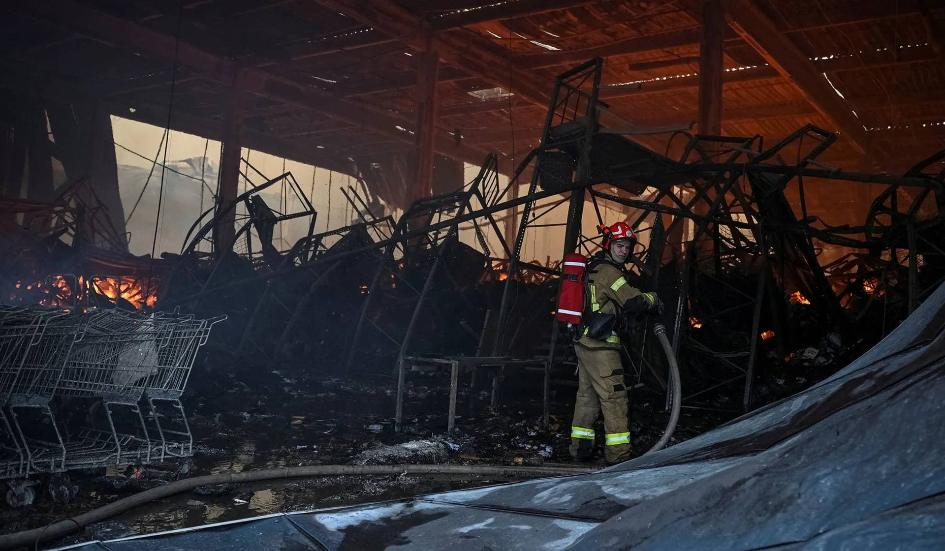 A firefighter works at the site of a Russian drone and missile strikes in Lviv