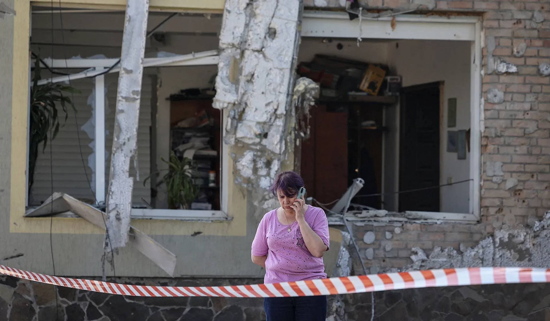 A local woman speaks on her mobile phone at the site of a Russian drone attack on the outskirts of Lviv