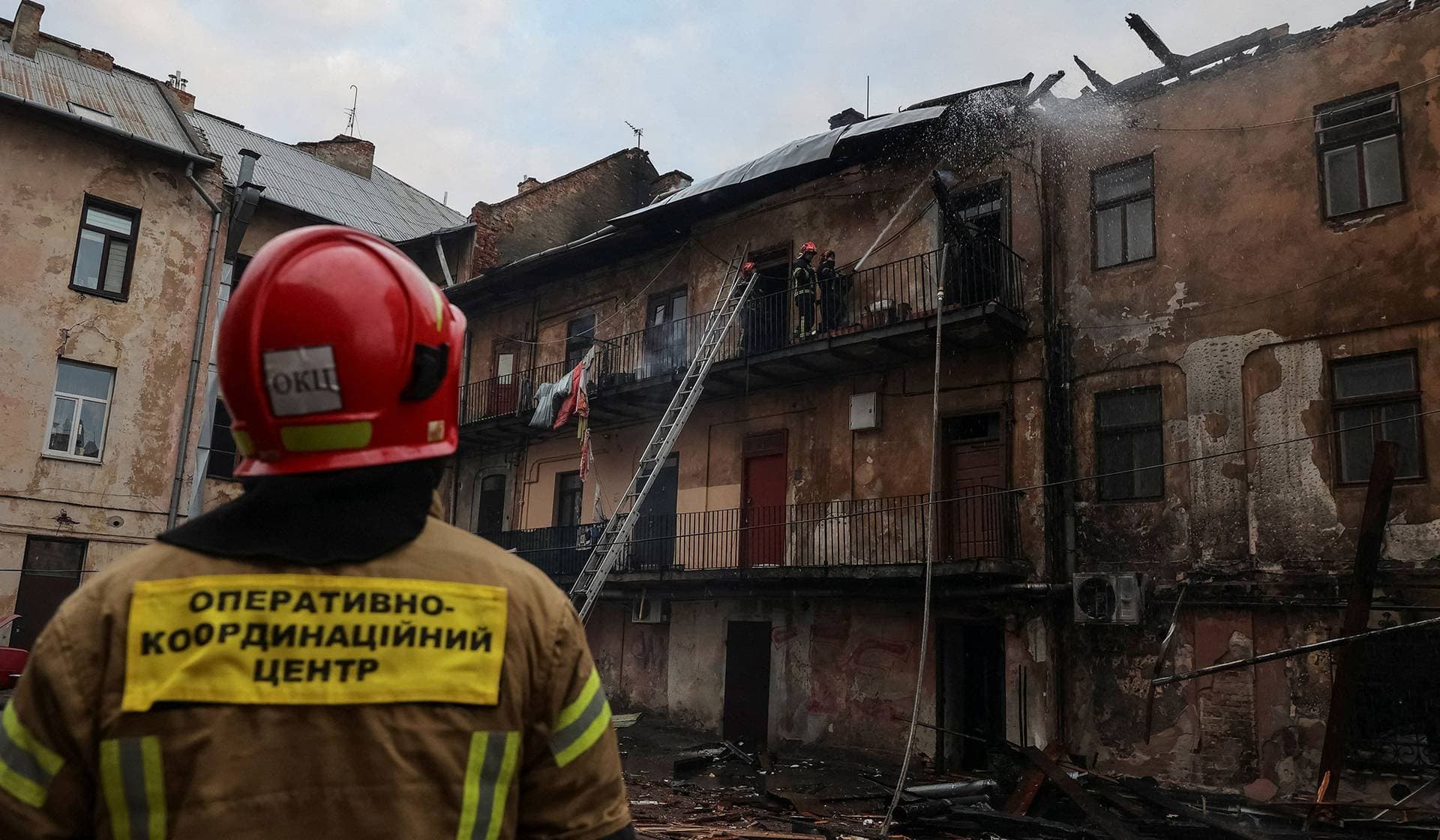 Firefighters work at the site of a building hit by a Russian drone strike in downtown Lviv