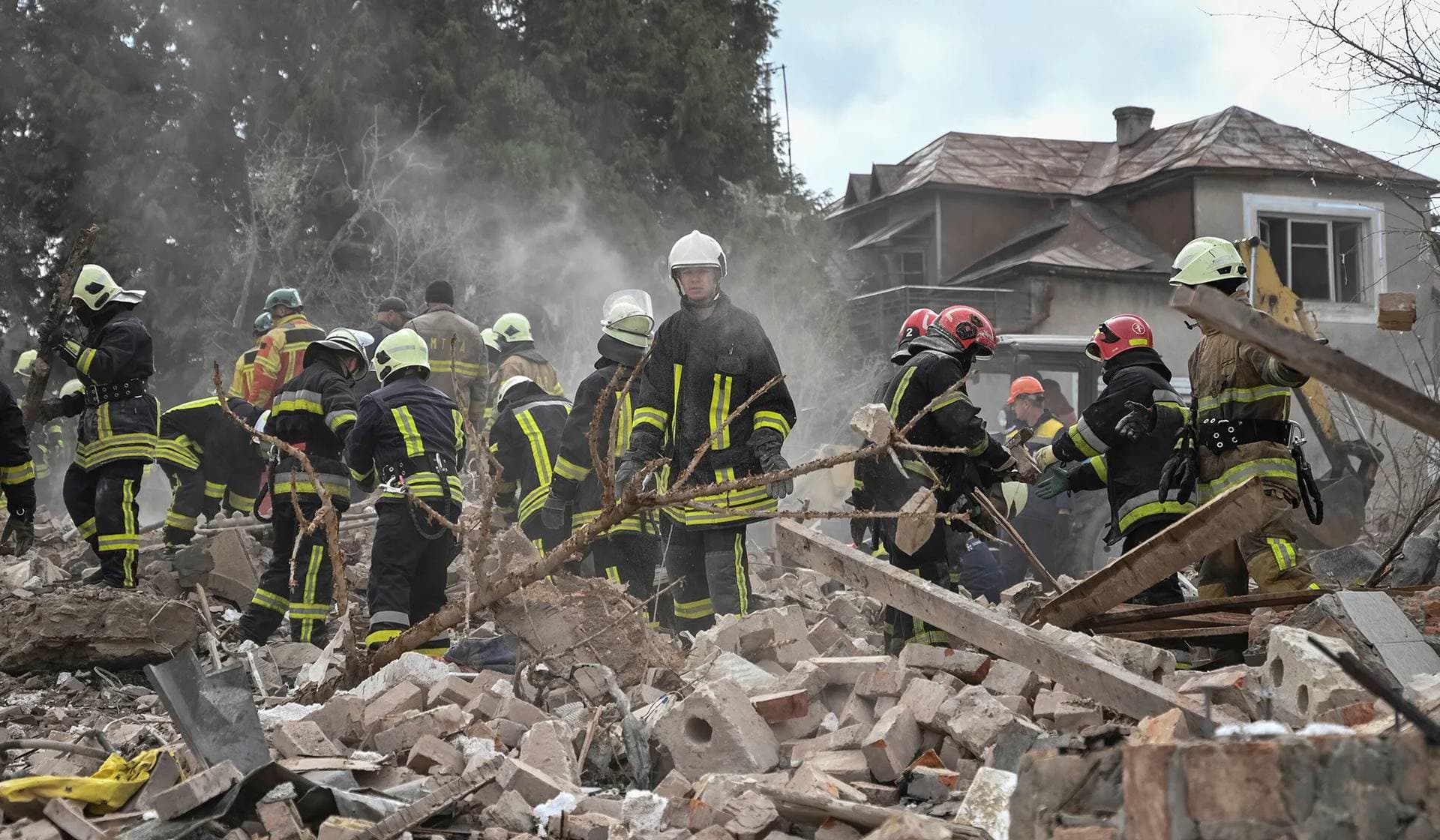 Rescuers work at the site of a house destroyed during a Russian drone and missile strike in the village of Lapaivka