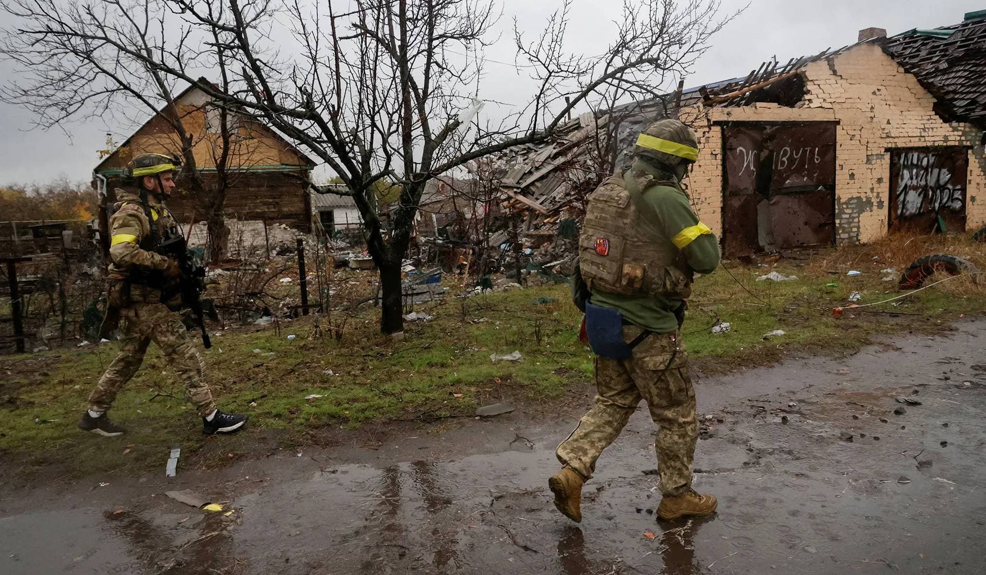 Servicemen of the 115th Separate Mechanized Brigade of the Ukrainian Armed Forces walk along a street in the frontline town of Lyman