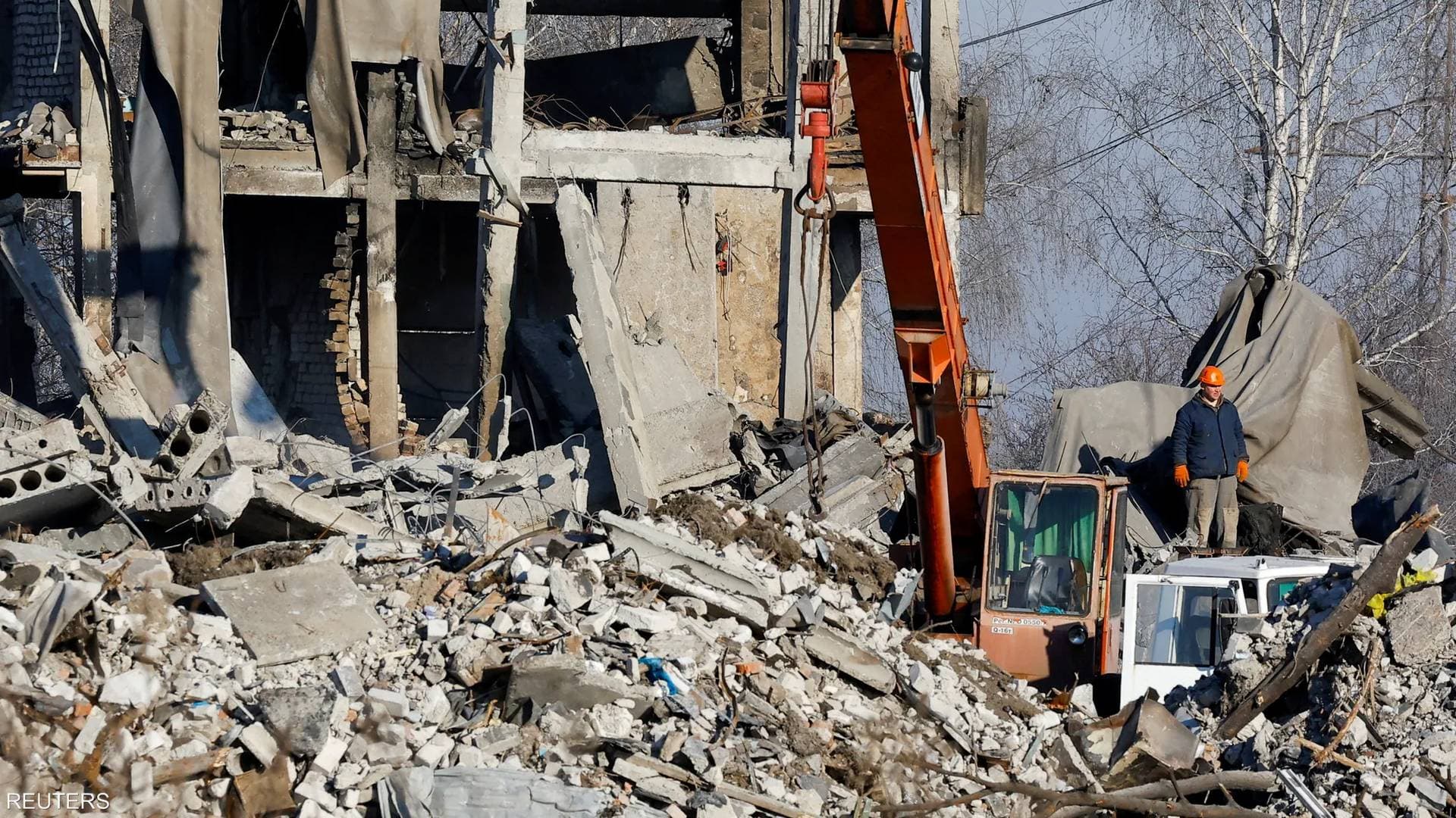 Workers and emergencies' ministry members remove debris of a destroyed building in the course of Russia-Ukraine conflict in Makiivka