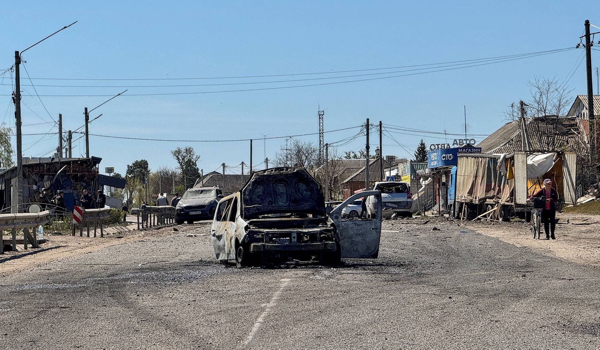 A burned car in a middle of a street at the site of a Russian missile strike in the town of Merefa in the Kharkiv Region