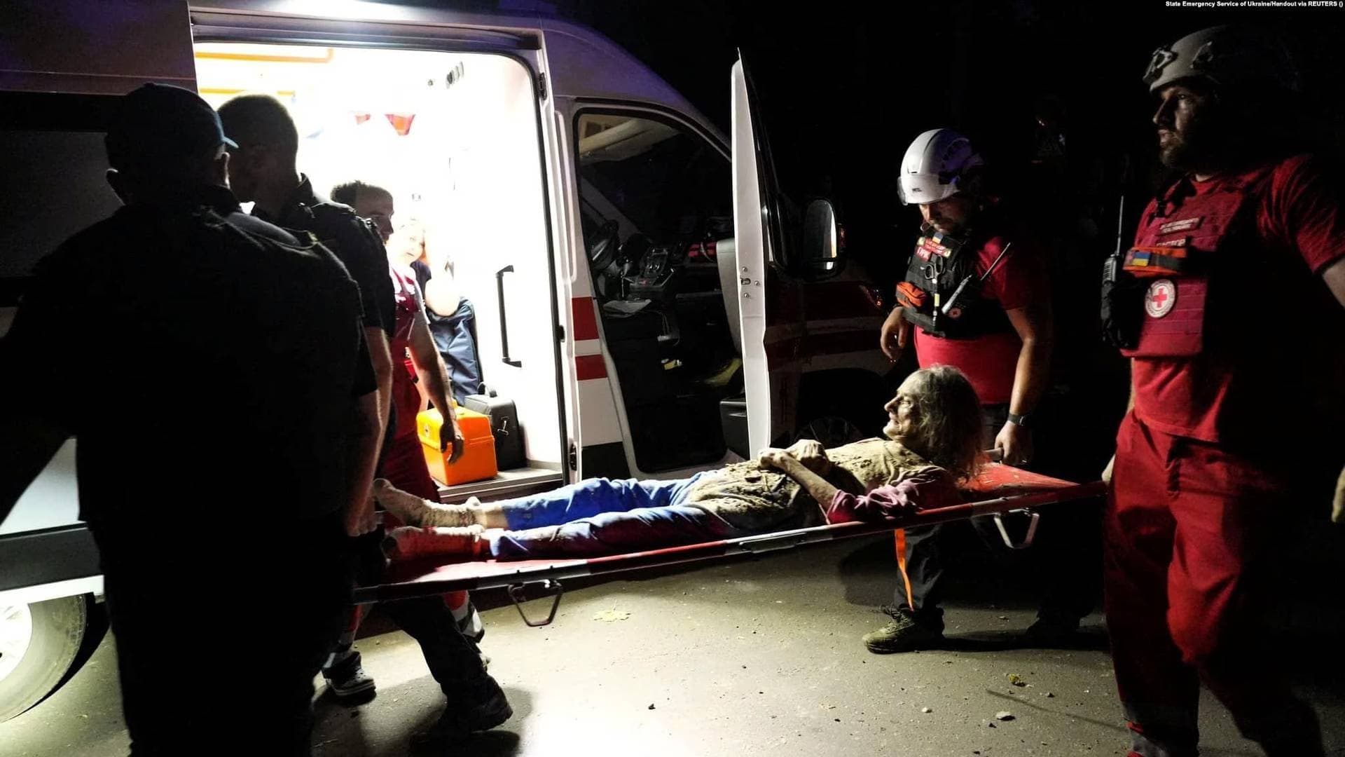Paramedics carry an injured woman at the site of a residential building heavily damaged by a Russian missile strike in Mykolayiv