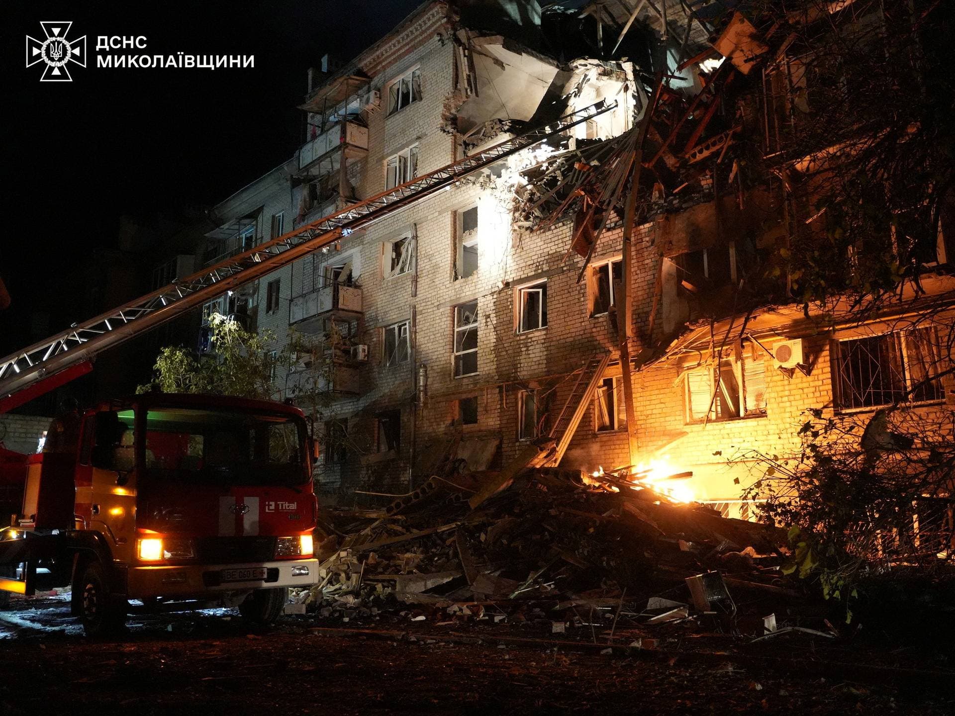Firefighters work at the site of an apartment building hit by a Russian drone strike in Mykolaiv