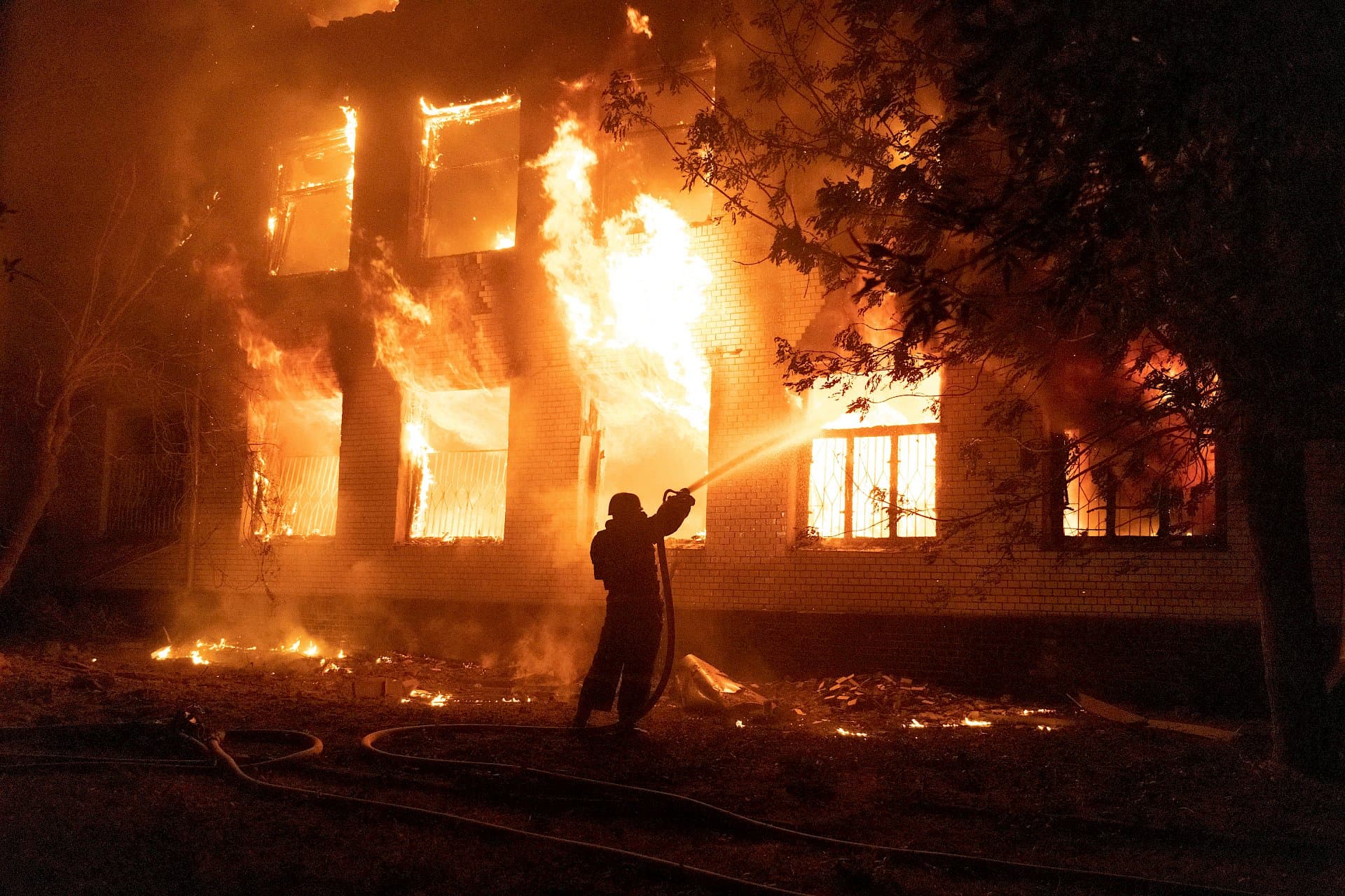 A firefighter extinguishes a burning hospital building hit by a Russian missile strike in Mykolaiv