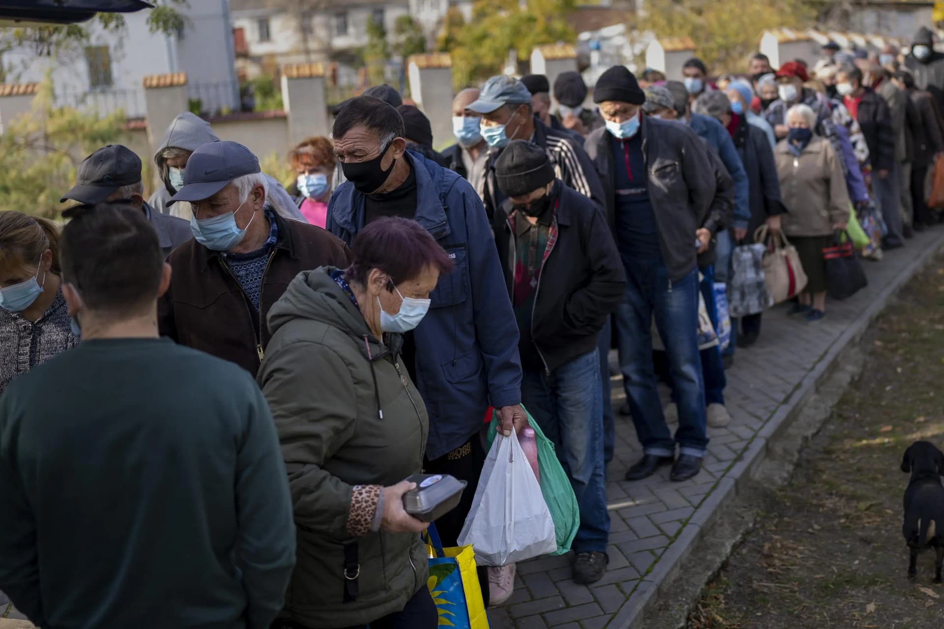 People queue up to wait a ration food from World Central Kitchen organisation in the center of Mykolaiv