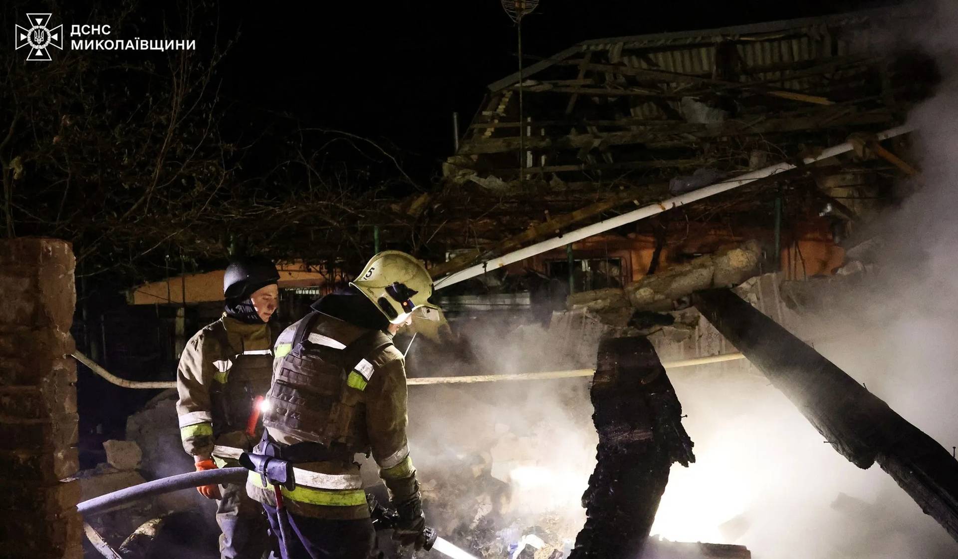 Firefighters work at a site of an apartment building hit by a Russian drone strike in Mykolaiv