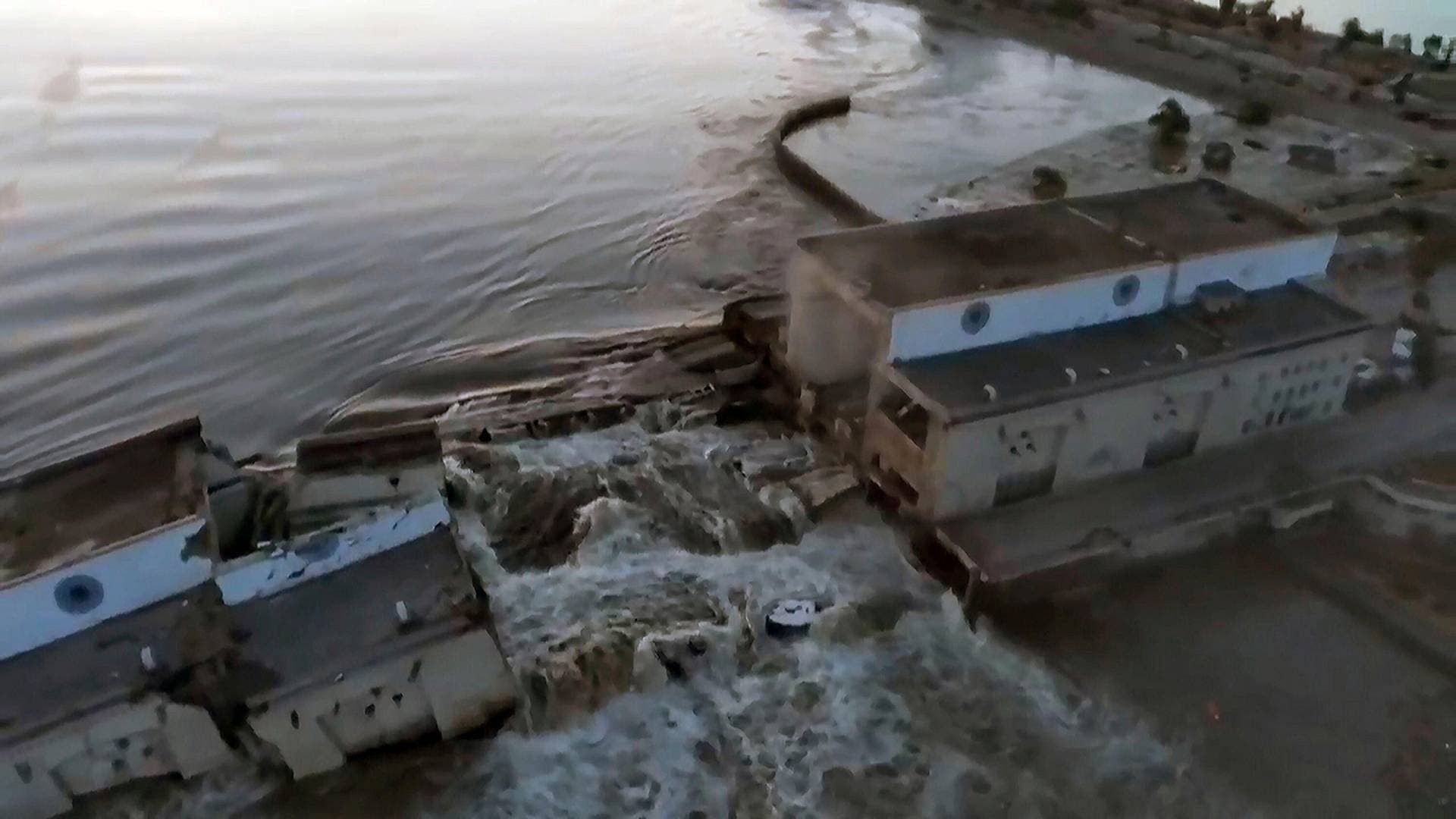 Water flows strongly through a breakthrough in the Kakhovka dam in Kakhovka