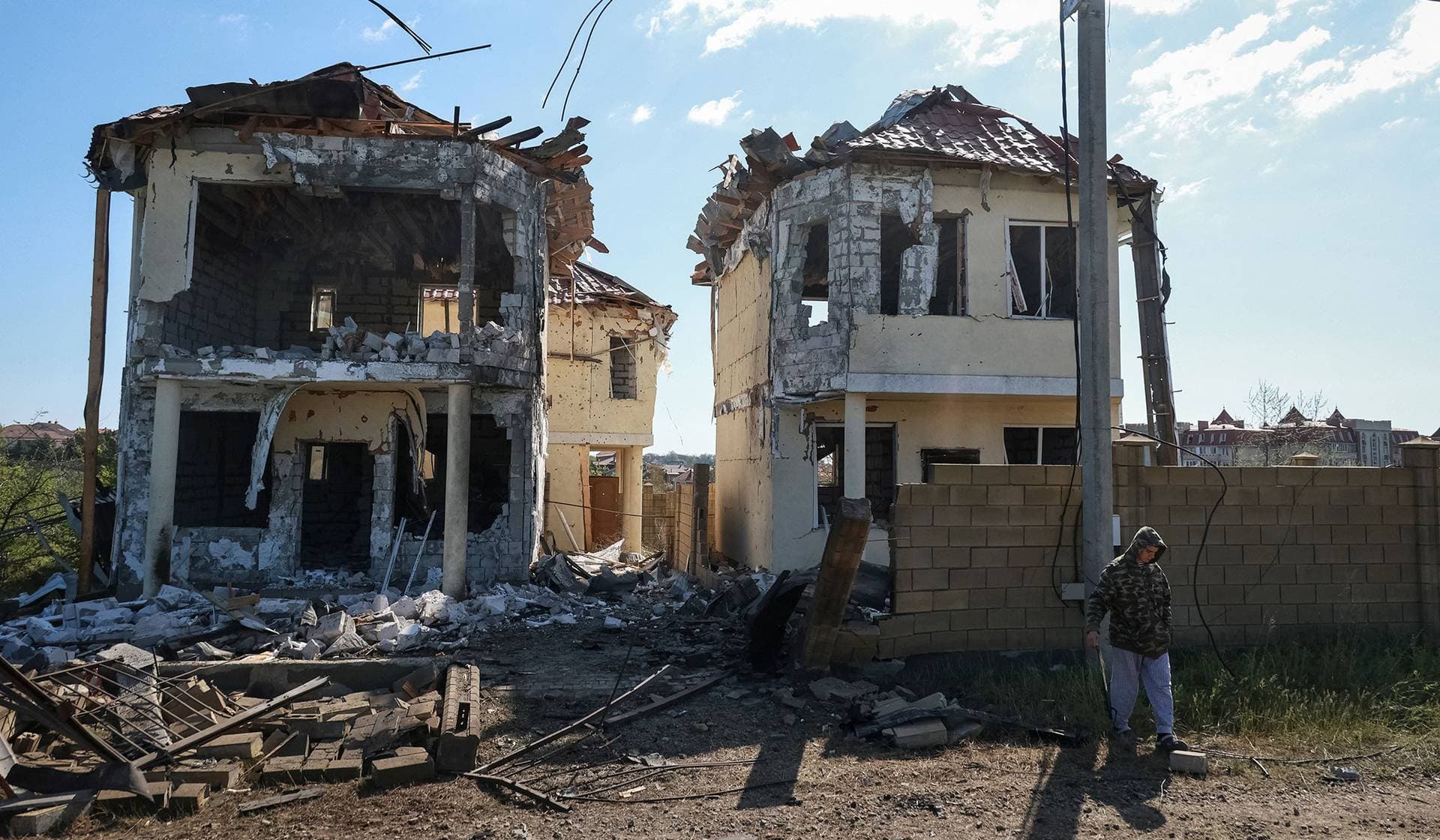 A resident stands near buildings damaged by a Russian drone strike near the city of Chornomorsk
