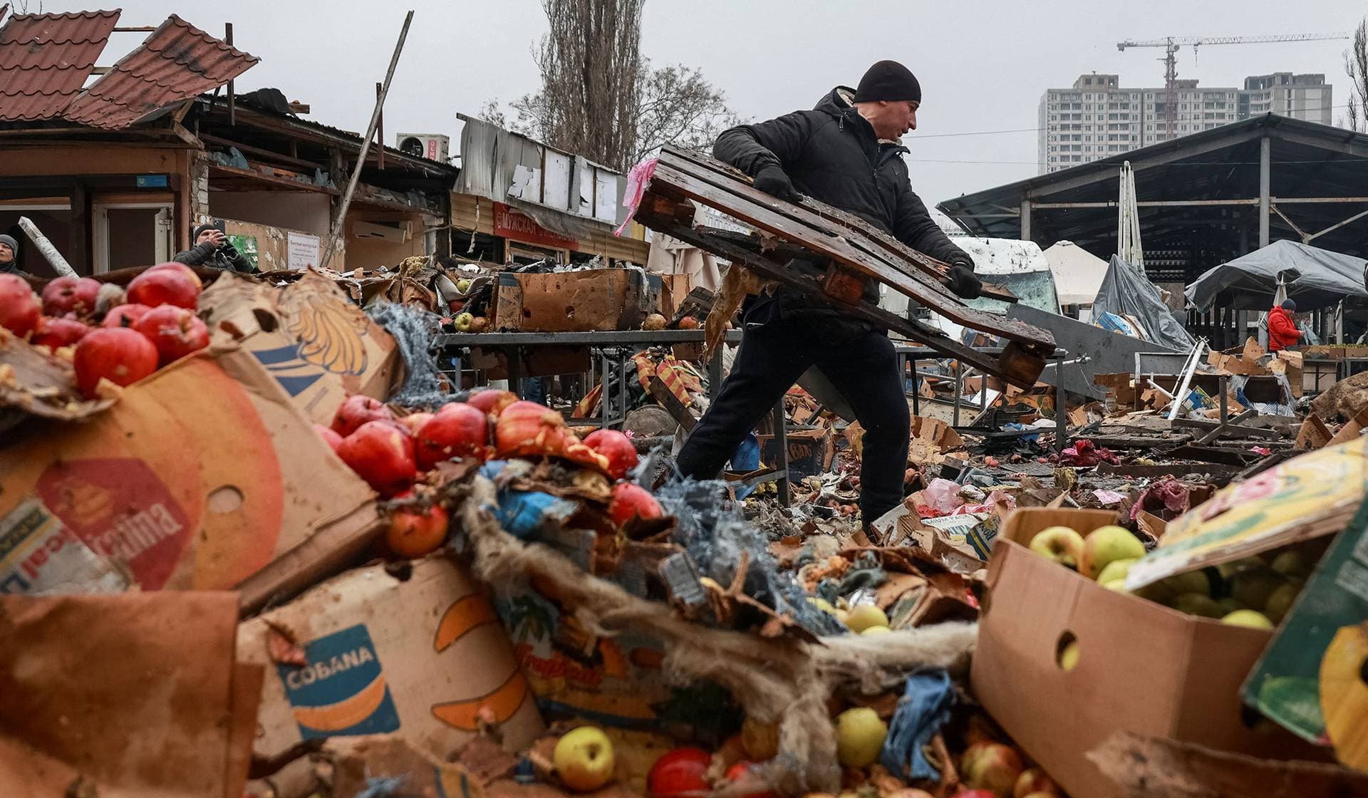A vendor cleans an area at a street market hit by a Russian drone strike in Odesa