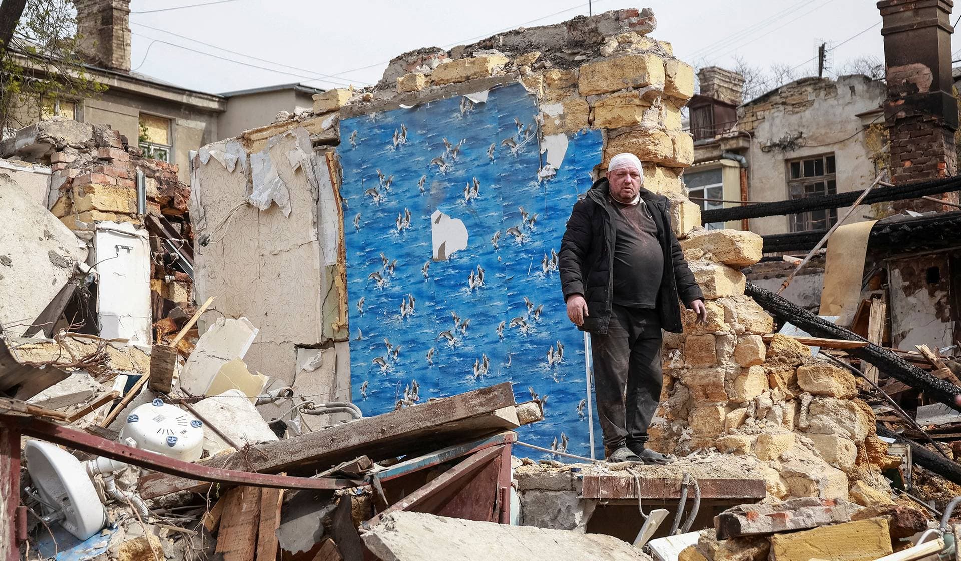 A wounded resident stands at the site of an apartment building hit by a Russian drone strike in Odesa