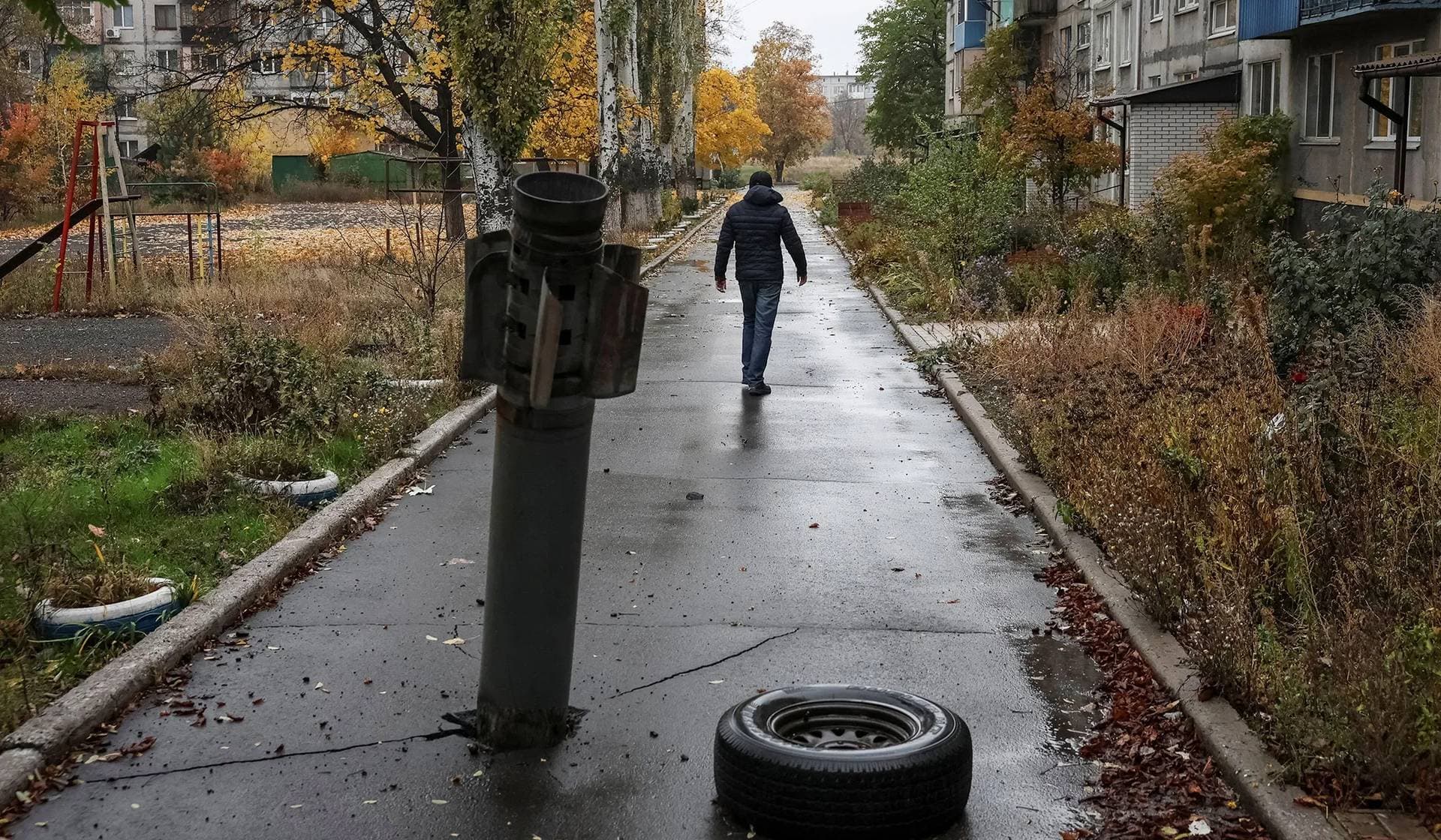 A resident walks near a part of a Russian missile in the frontline town of Dobropillia