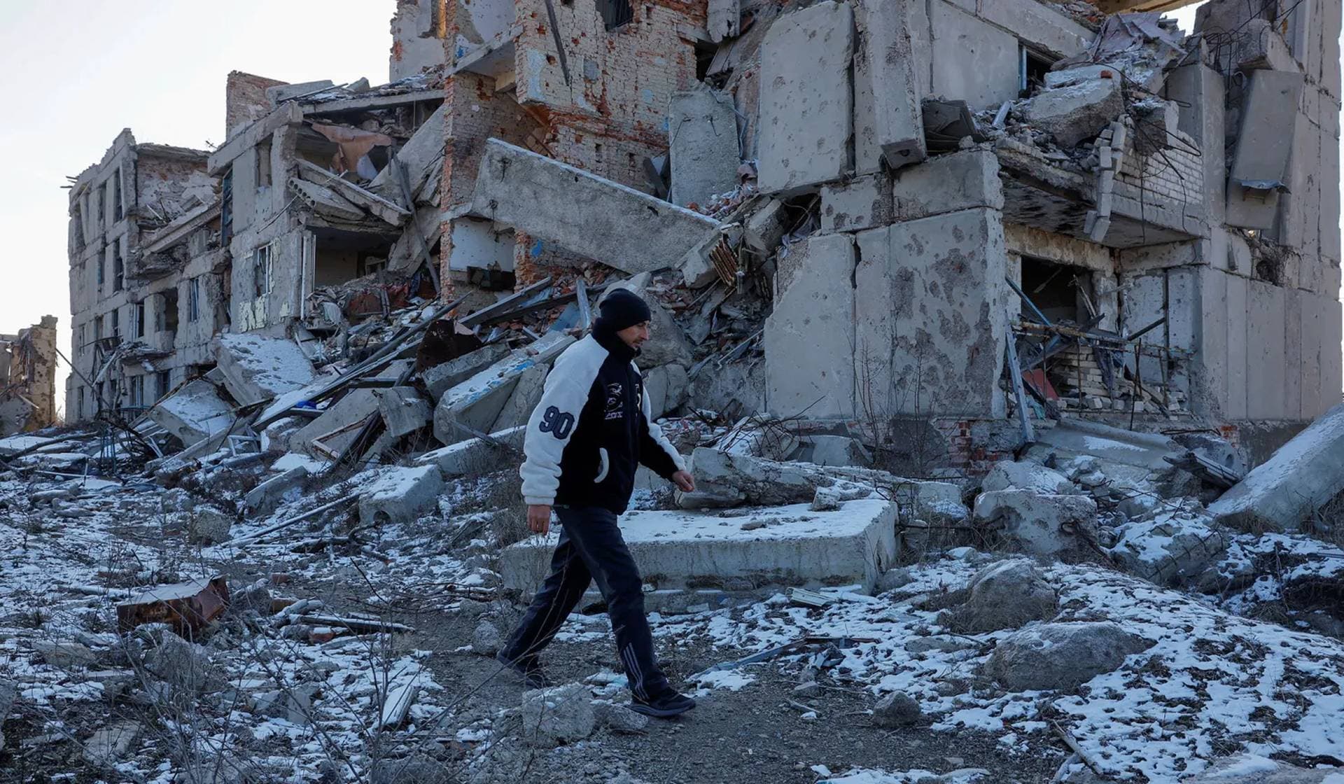 Yevgeniy Bystrov walks near his former house destroyed in Pisky