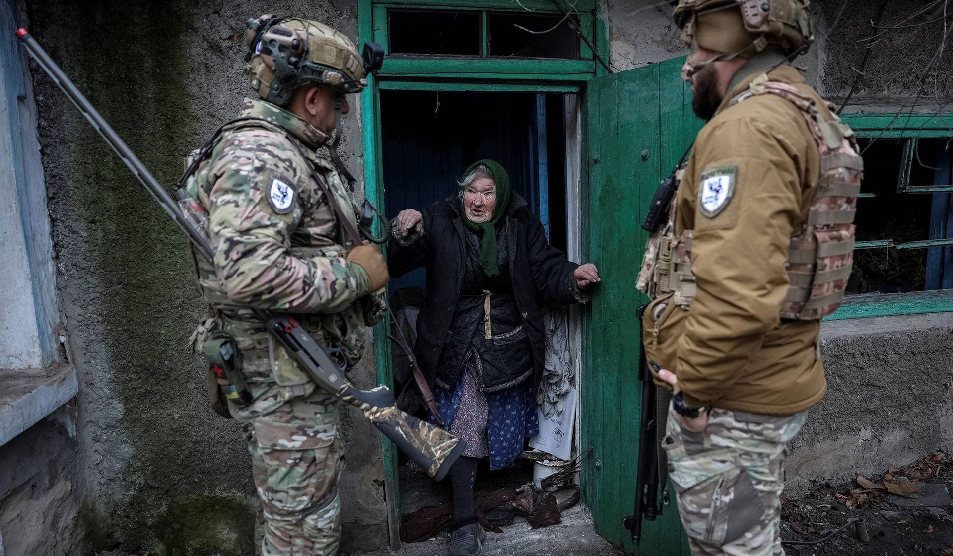 Members of the White Angels police evacuation unit speak with a resident during an evacuation from the frontline town of Dobropillia