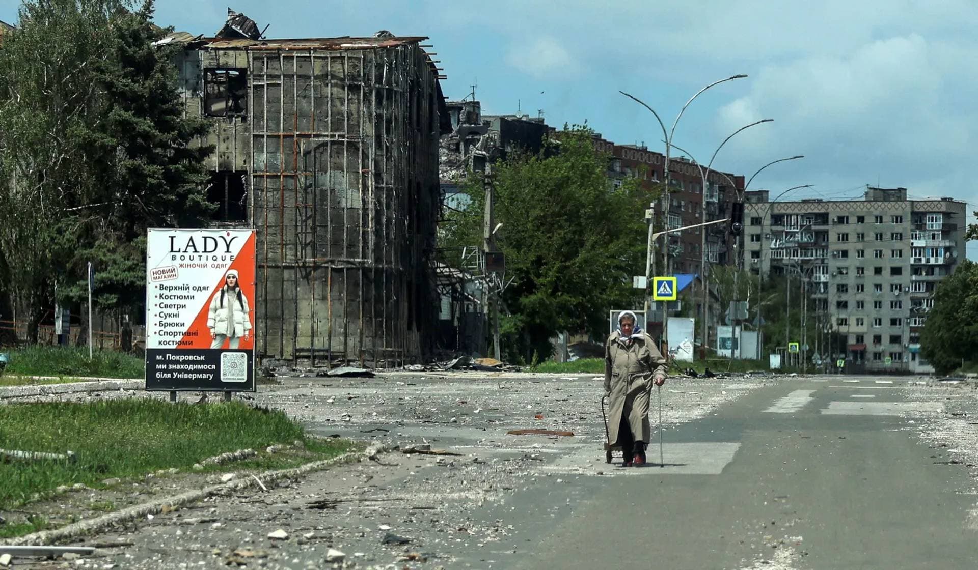 A resident walks at a street near buildings damaged by Russian military strikes in the frontline town of Pokrovsk