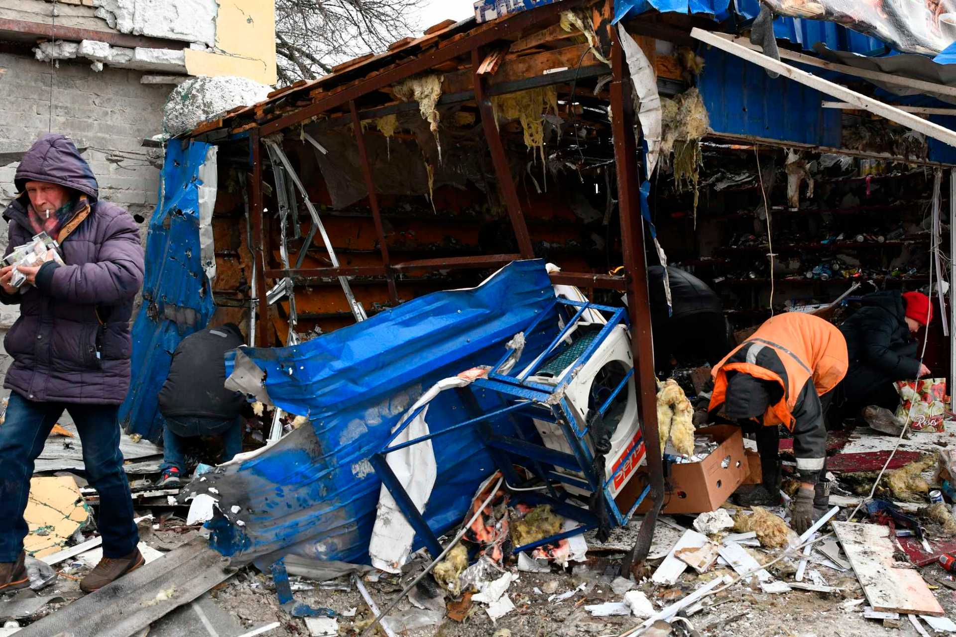 People take cigarettes from a ruined shop in Kurakhove