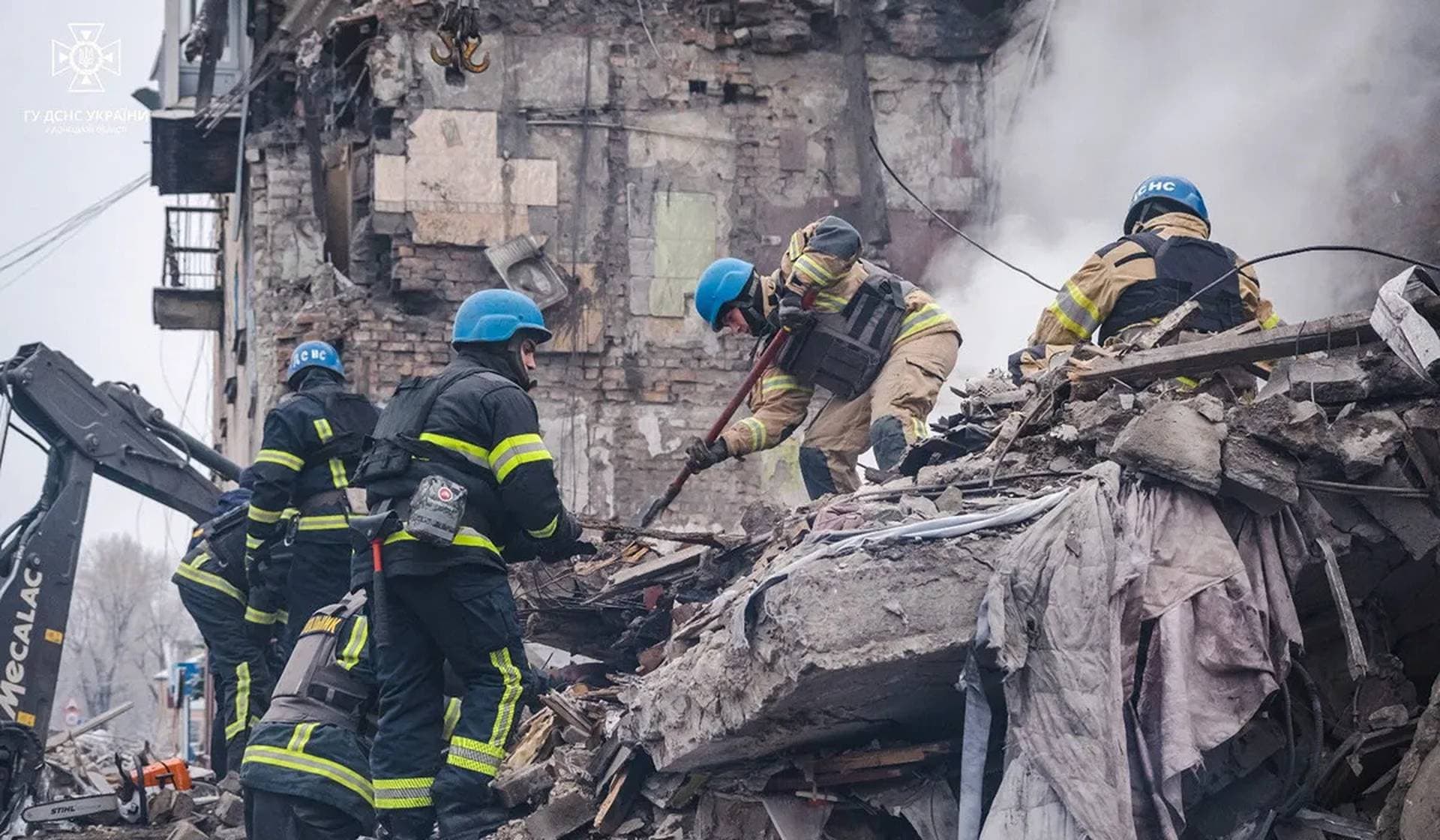Rescues work at a site of a residential building heavily damaged by a Russian missile strike in the town of Novohrodivka