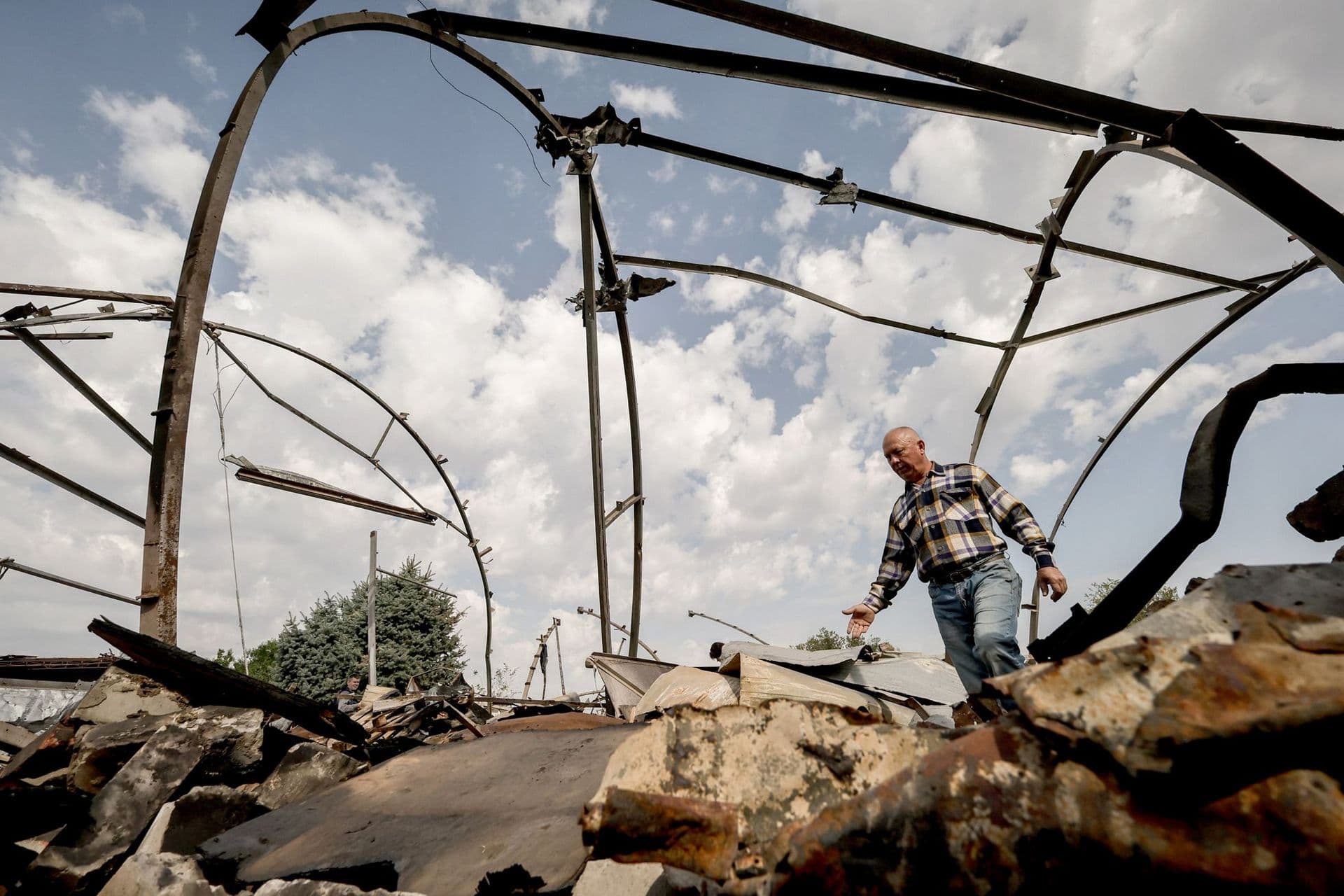 Ukrainian farmer inspects the rubble of a destroyed grain storage on his farm, near the frontline town of Orikhiv