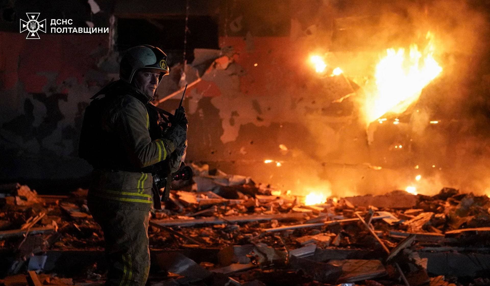 A firefighter works at the site of a building damaged during overnight Russian drone and missile strikes in Poltava