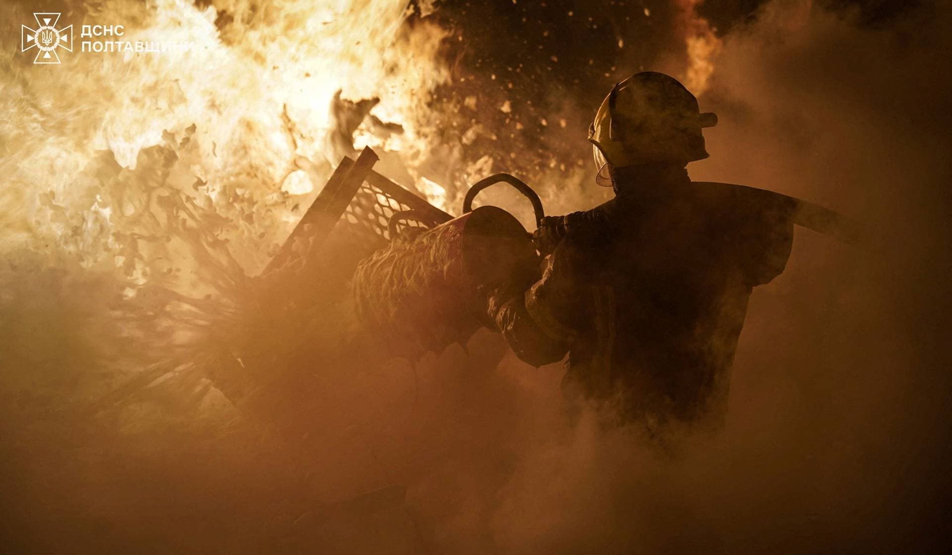 A firefighter works at the site of an industrial enterprise hit by overnight Russian drone strikes in Poltava Region