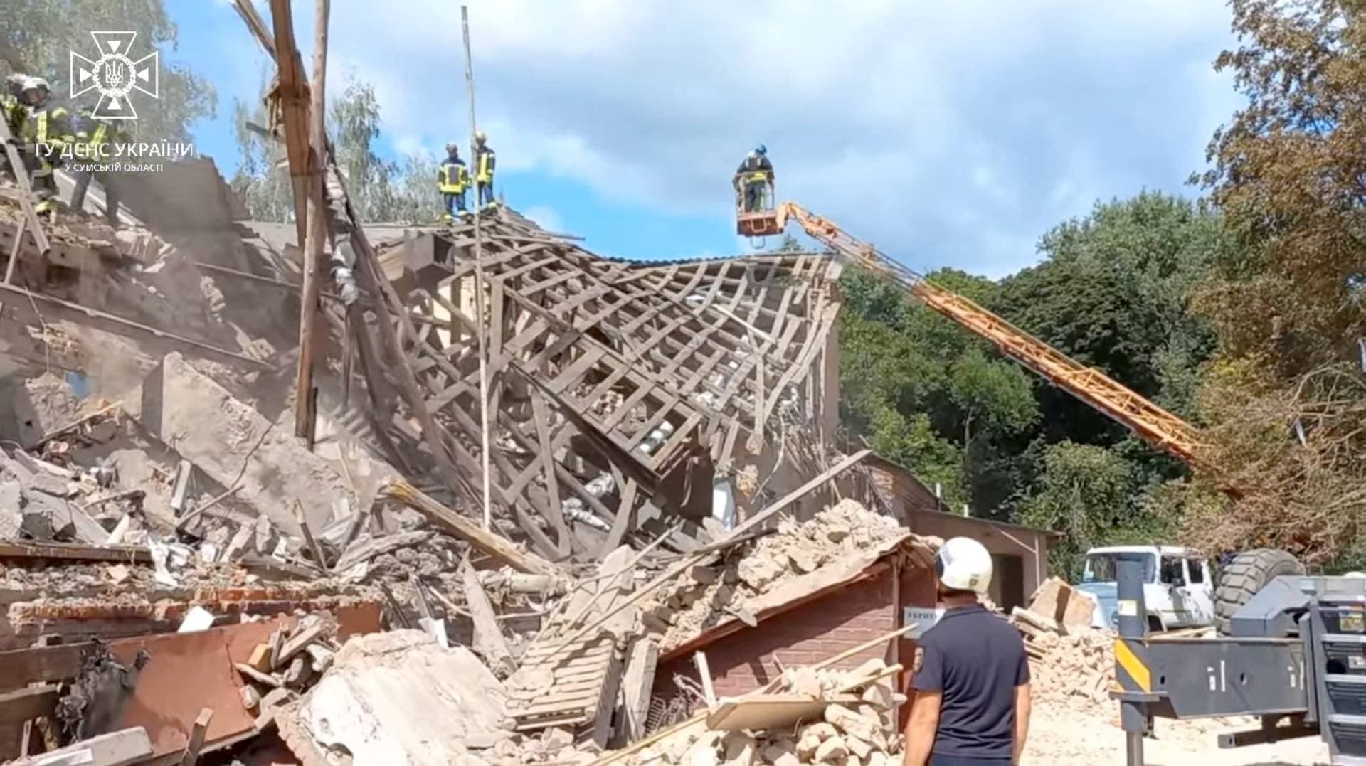 Rescuers work at the site of a Russian drone strike in Romny