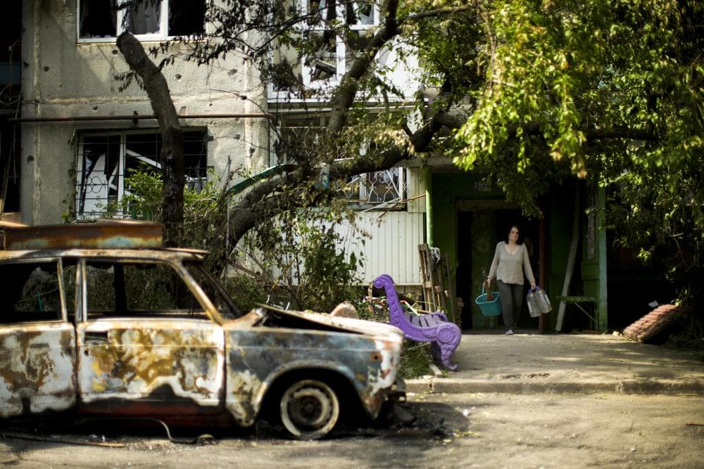 Olena Voutenko leaves her home in a building damaged in an overnight missile strike in Sloviansk