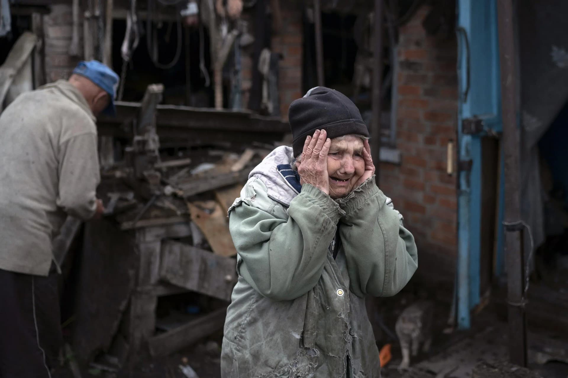 Valentina Bondarenko reacts as she stands with her husband Leonid outside their house that was heavily damaged after a Russian attack in Sloviansk