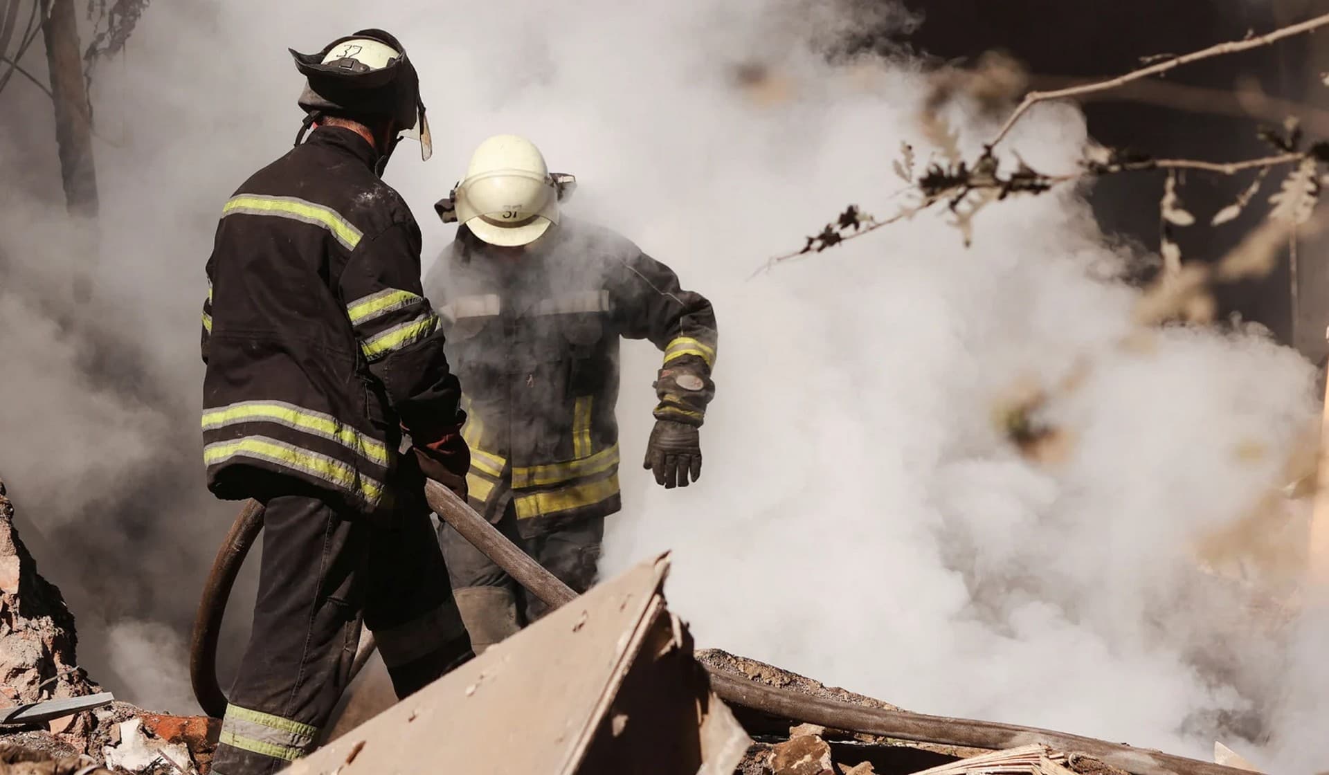 Ukrainian firefighters work to put out a fire at a destroyed residential building after a Russian military strike in Slovyansk