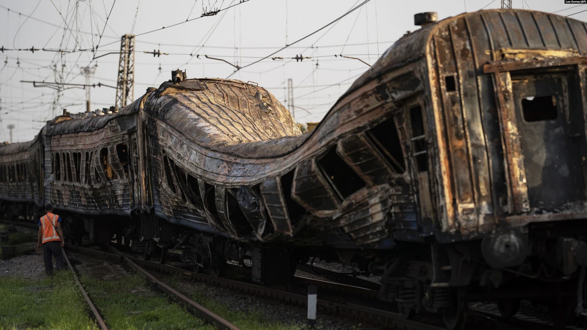 Railway workers verify a heavily damaged train after a Russian attack on a train station Wednesday during Ukraine's Independence Day in the village Chaplyne