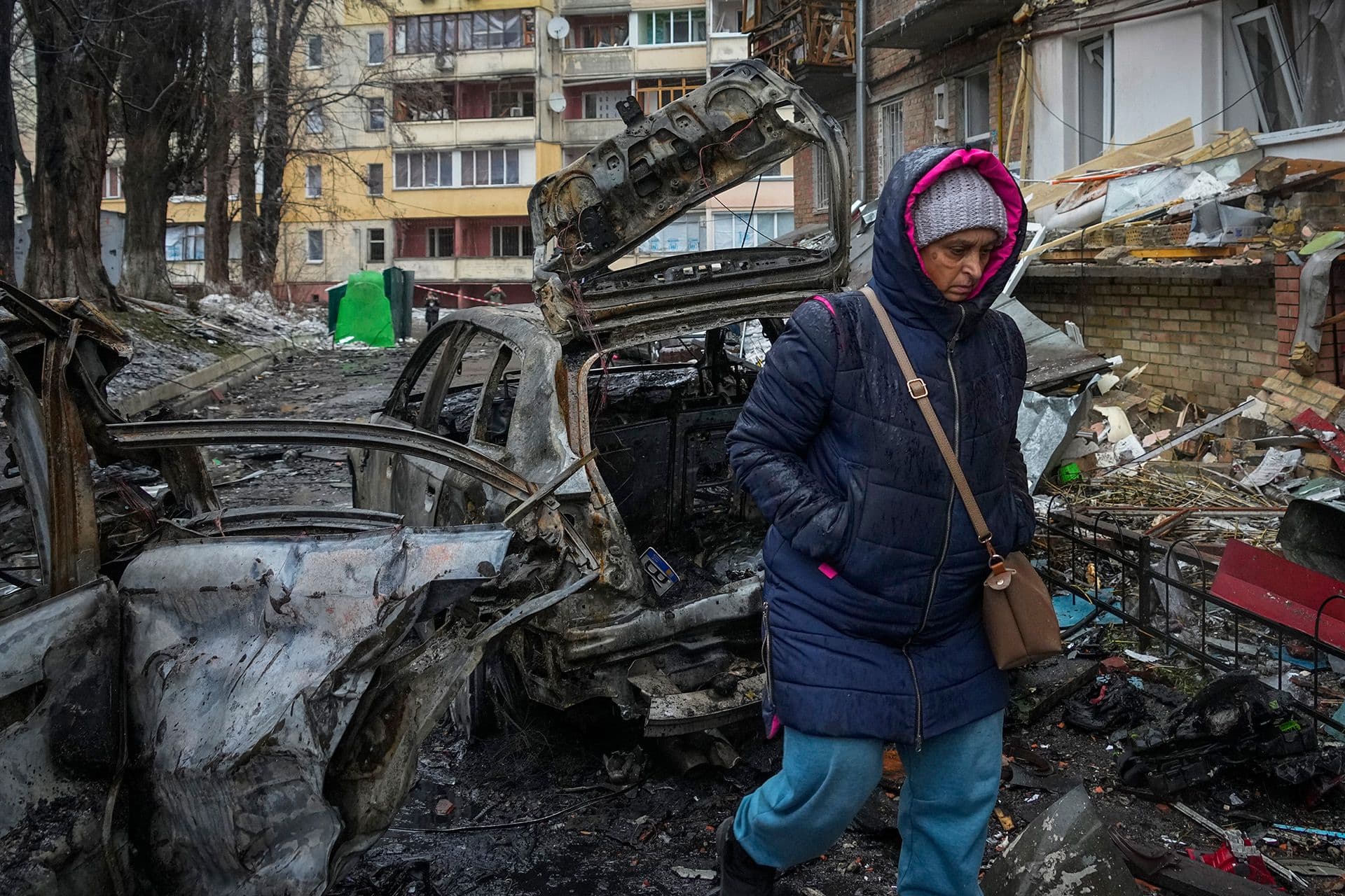 A woman walks by house damaged during Russian shelling in the town of Vyshgorod
