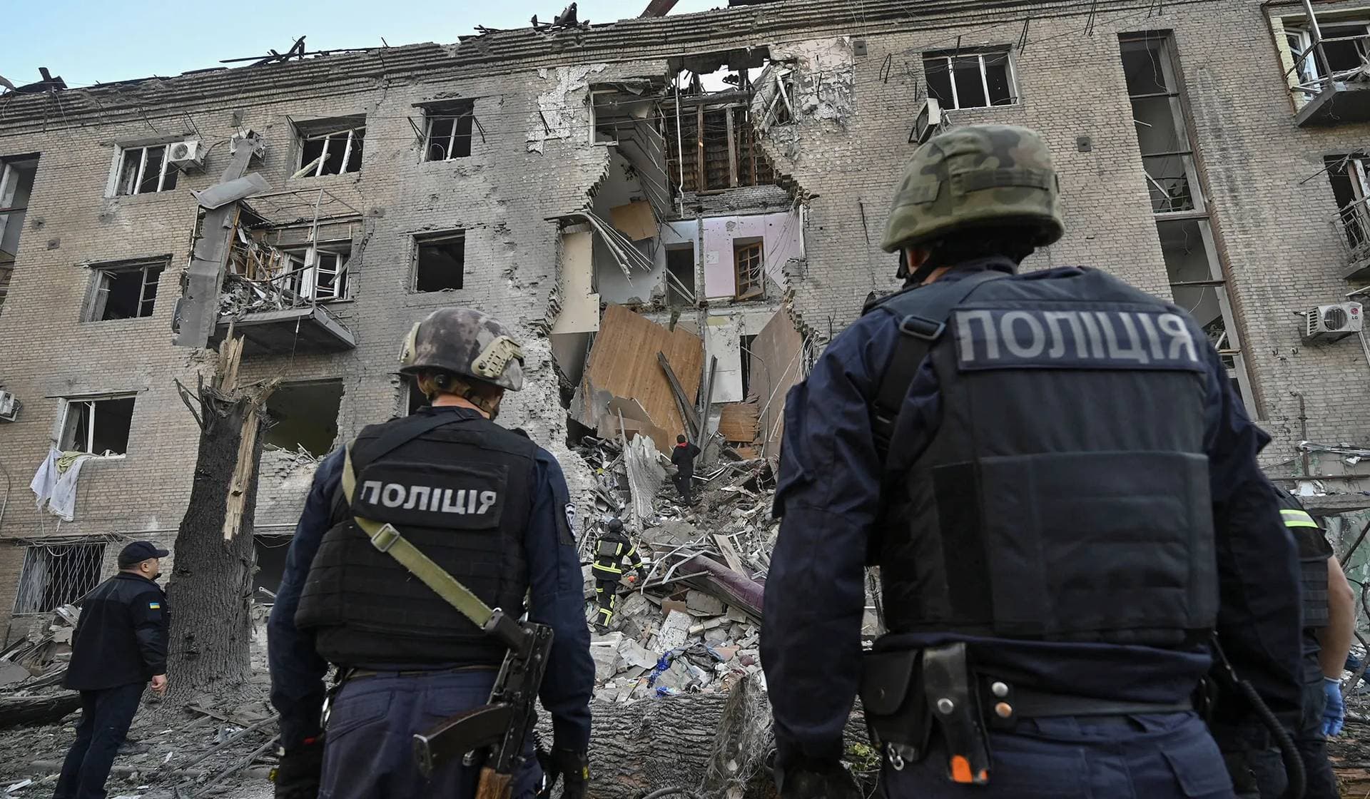 Police officers stand in front of an apartment building hit by a Russian air strike in Zaporizhzhia