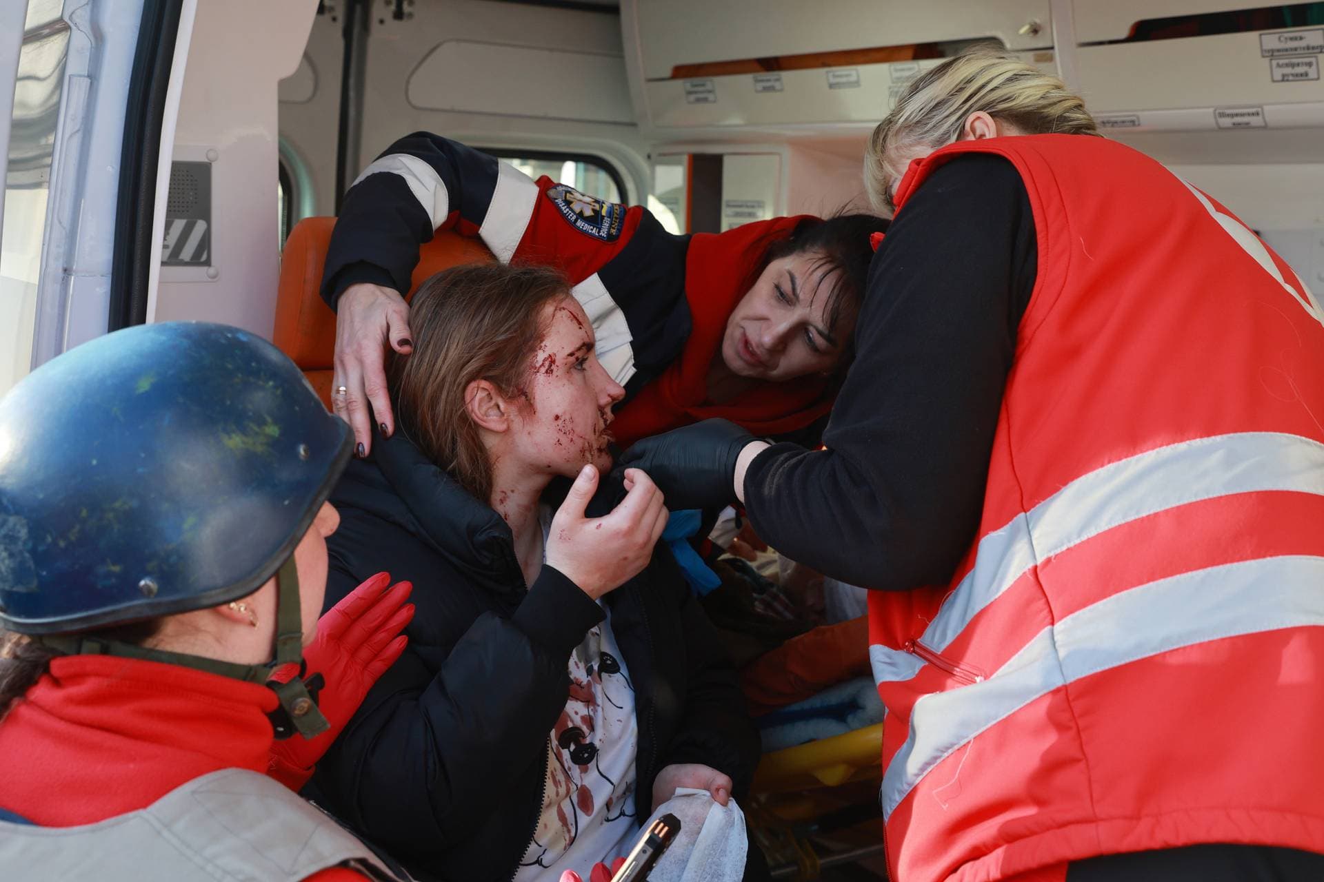 Paramedics give first aid to an injured resident following Russian aerial guided bomb strike in Zaporizhzhia