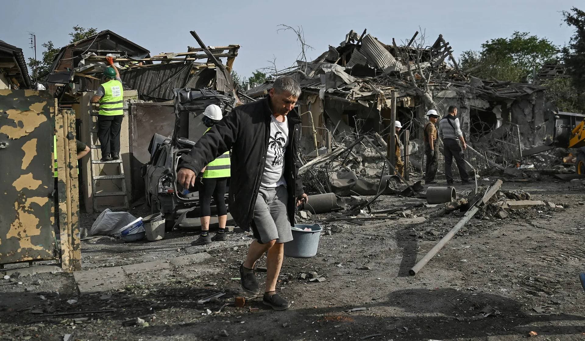 A man removes debris at a site of a residential area heavily damaged by a Russian air strike in Zaporizhzhia