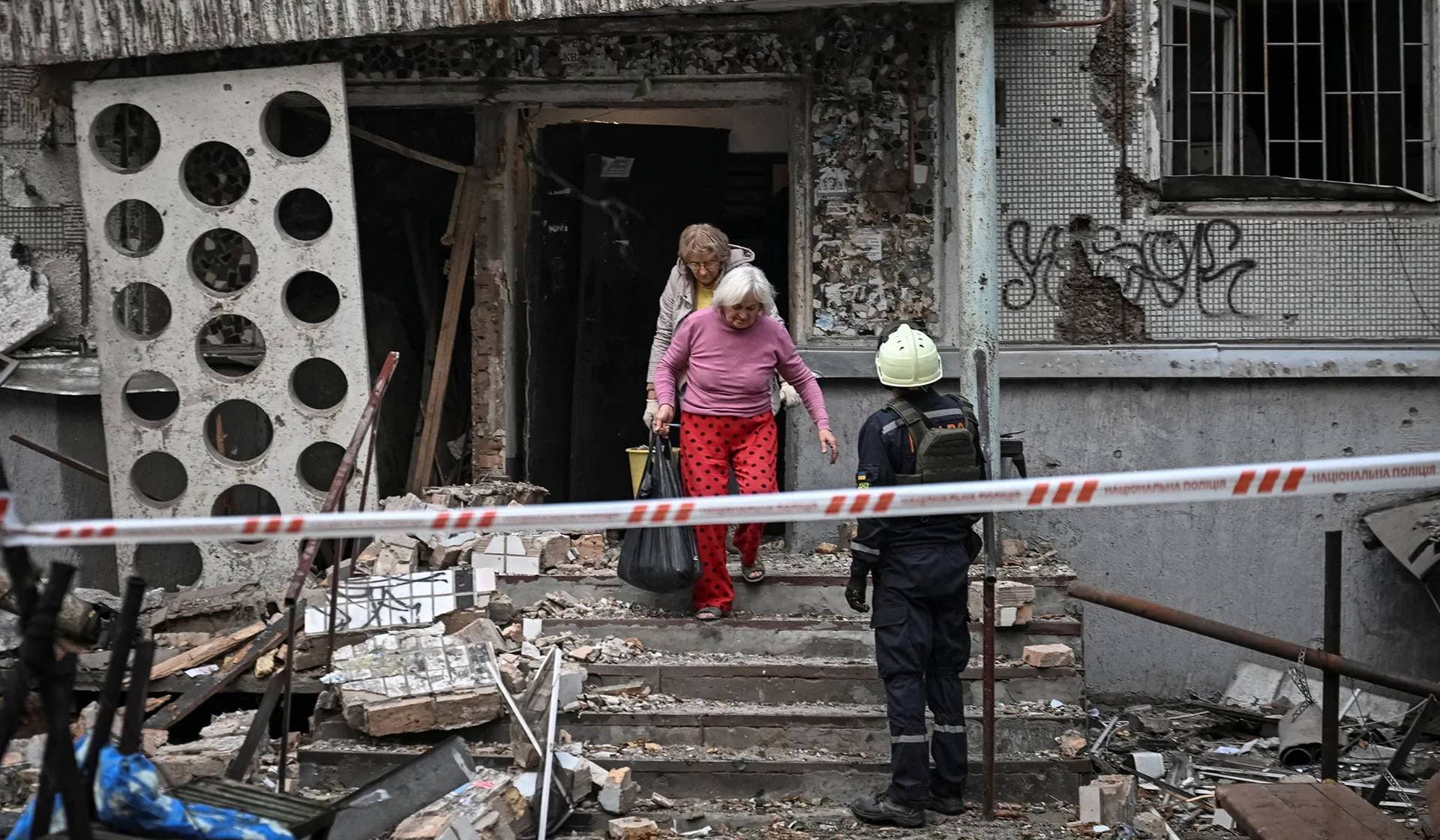 Residents leave their apartment building damaged by a Russian drone strike in Zaporizhzhia