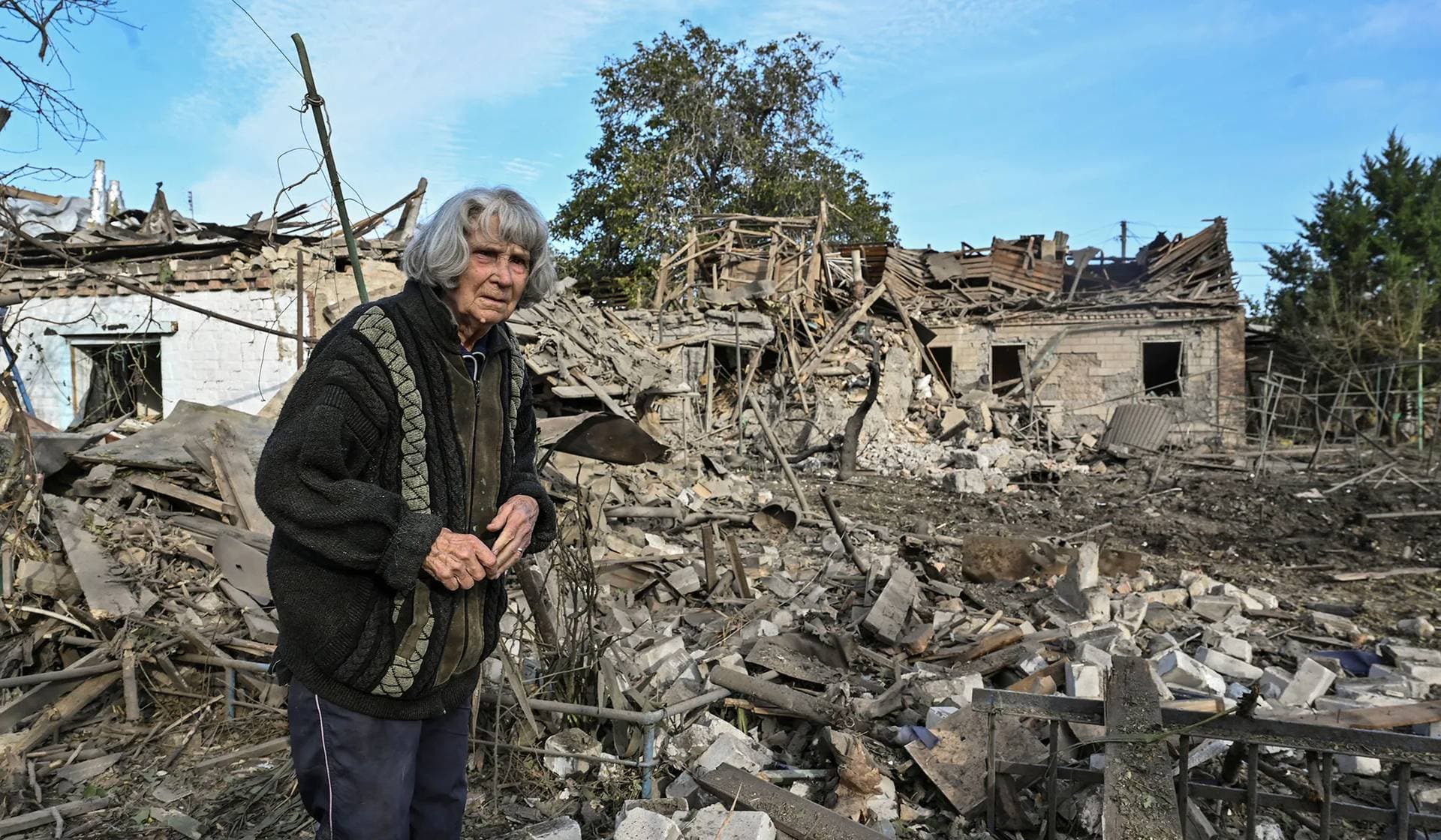 A woman stands in the backyard of her house destroyed by a Russian air strike in Zaporizhzhia