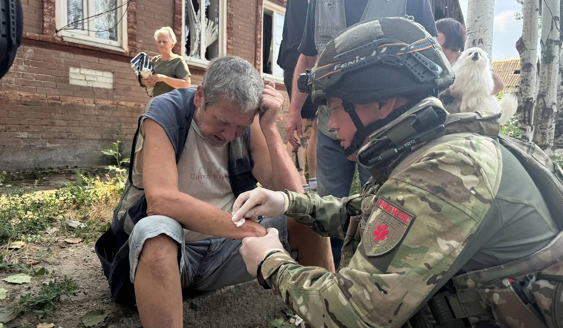 A police member treats a resident at the site of a Russian drone strike in Zaporizhzhia
