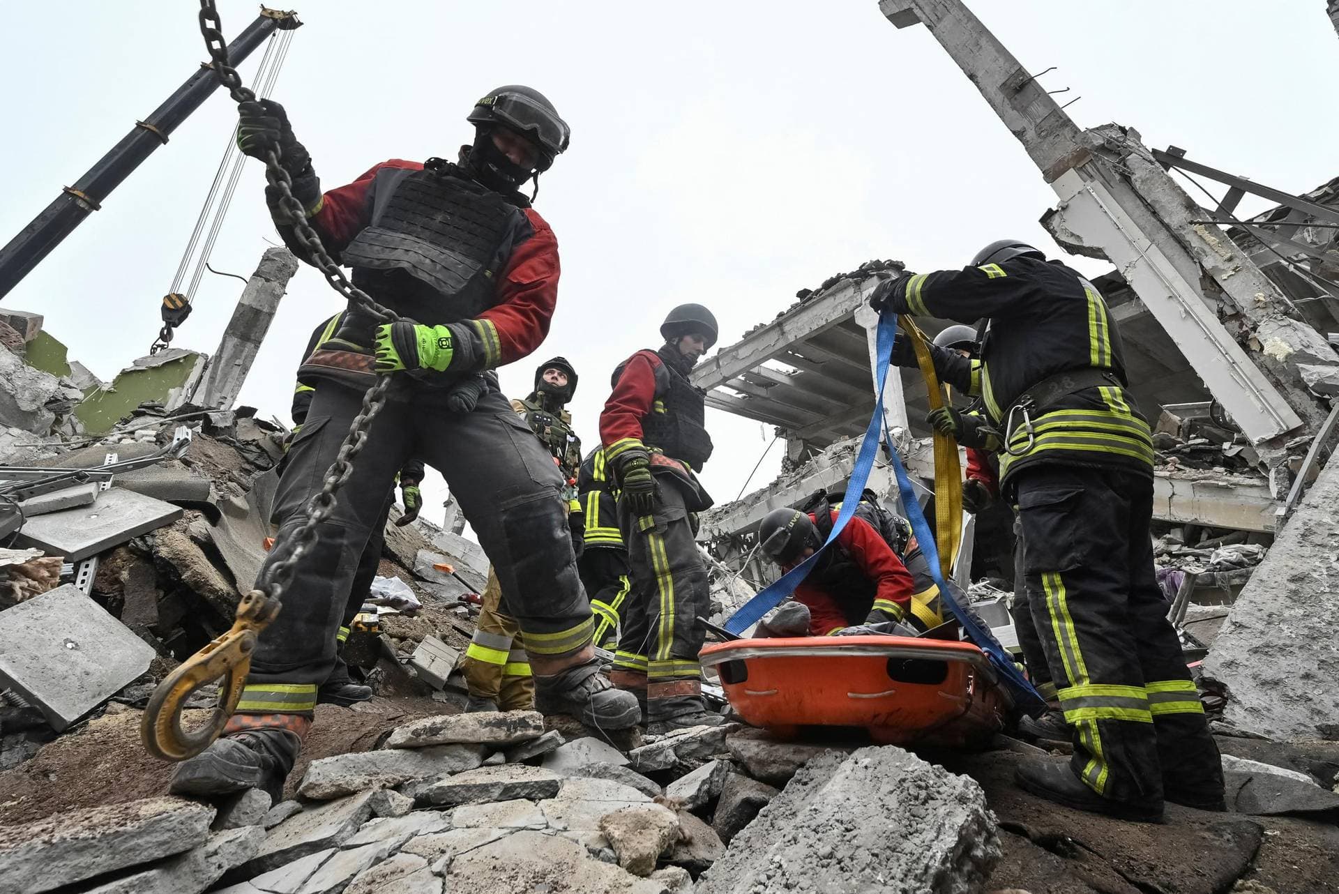 Rescuers prepare to lift the body of a person pulled out from the debris of a building which was heavily damaged by yesterday's Russian missile strike in Zaporizhzhia