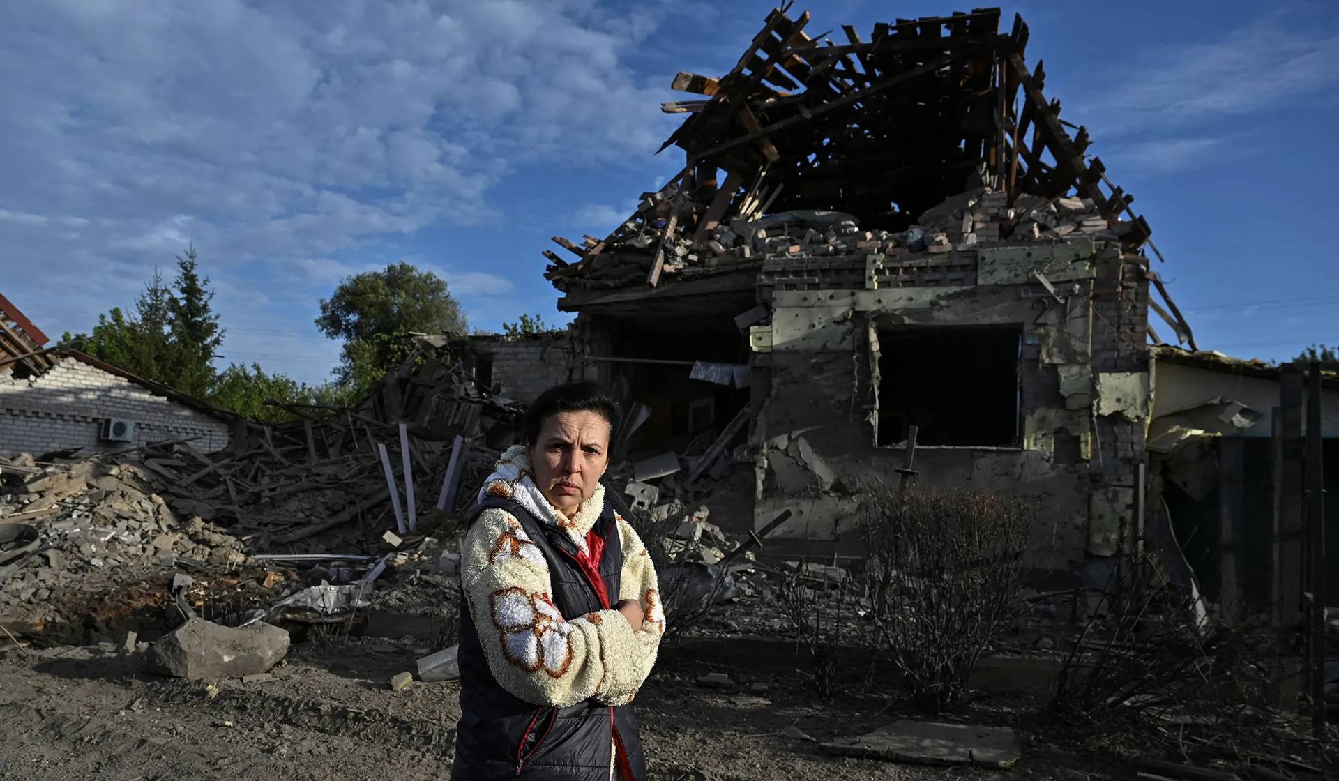 A woman walks next to a house heavily damaged by a Russian air strike in Zaporizhzhia