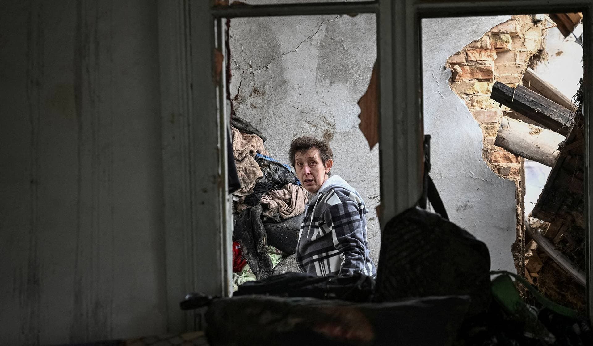 A woman looks at her house damaged by a Russian drone strike in Zaporizhzhia